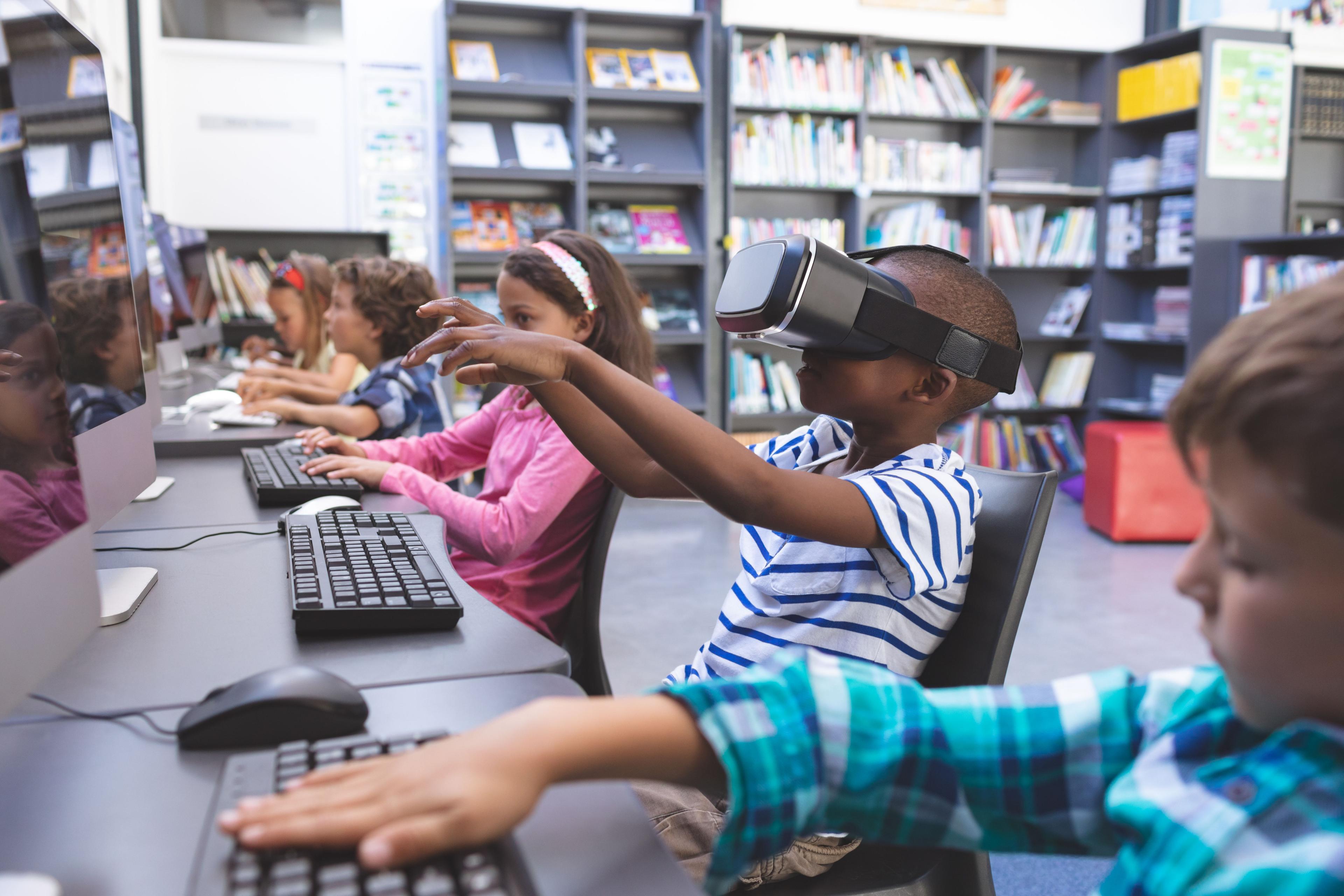 elementary aged boy wearing vr headset in school library