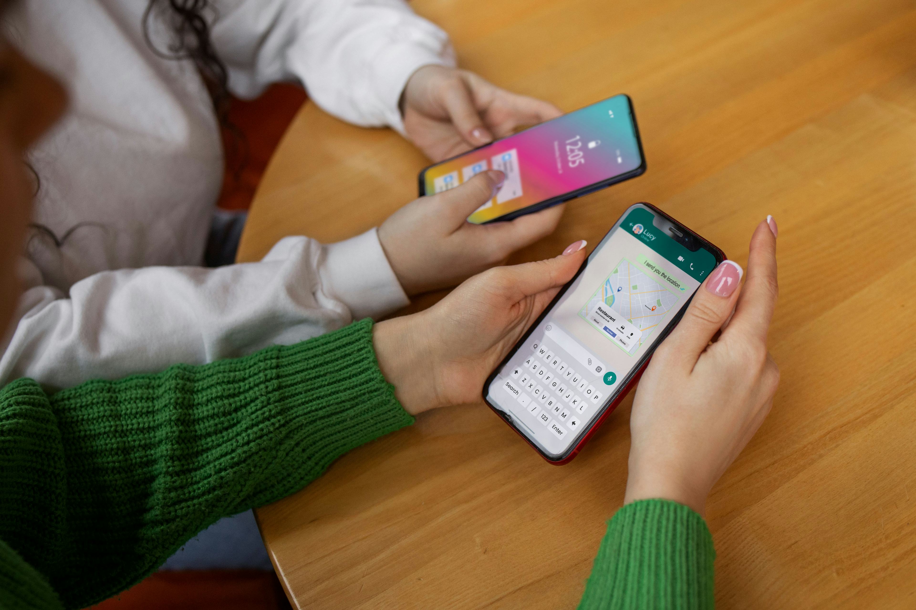 High angle friends holding smartphones