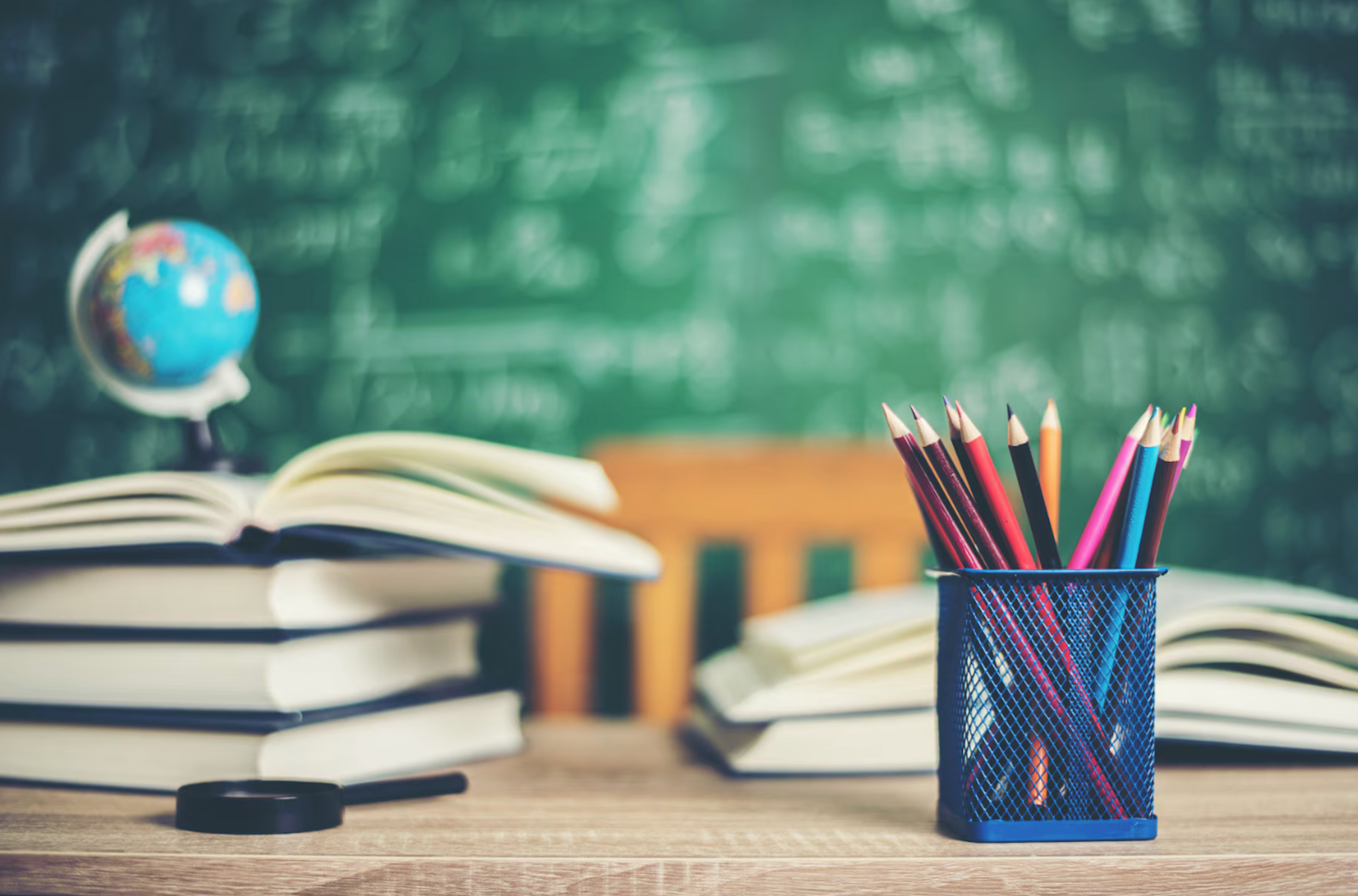 stack of books with globe on top of them and a pencil holder