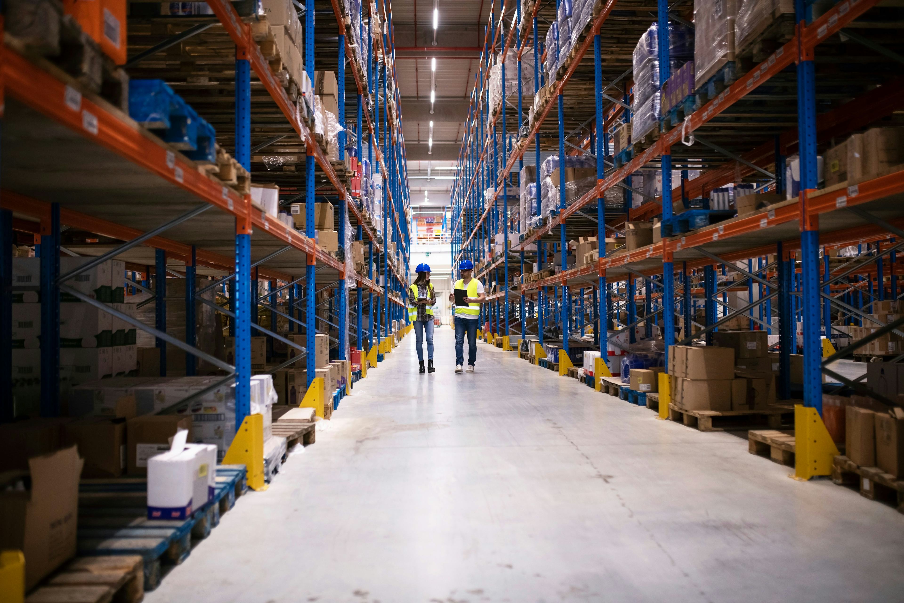 workers in warehouse viewing charts