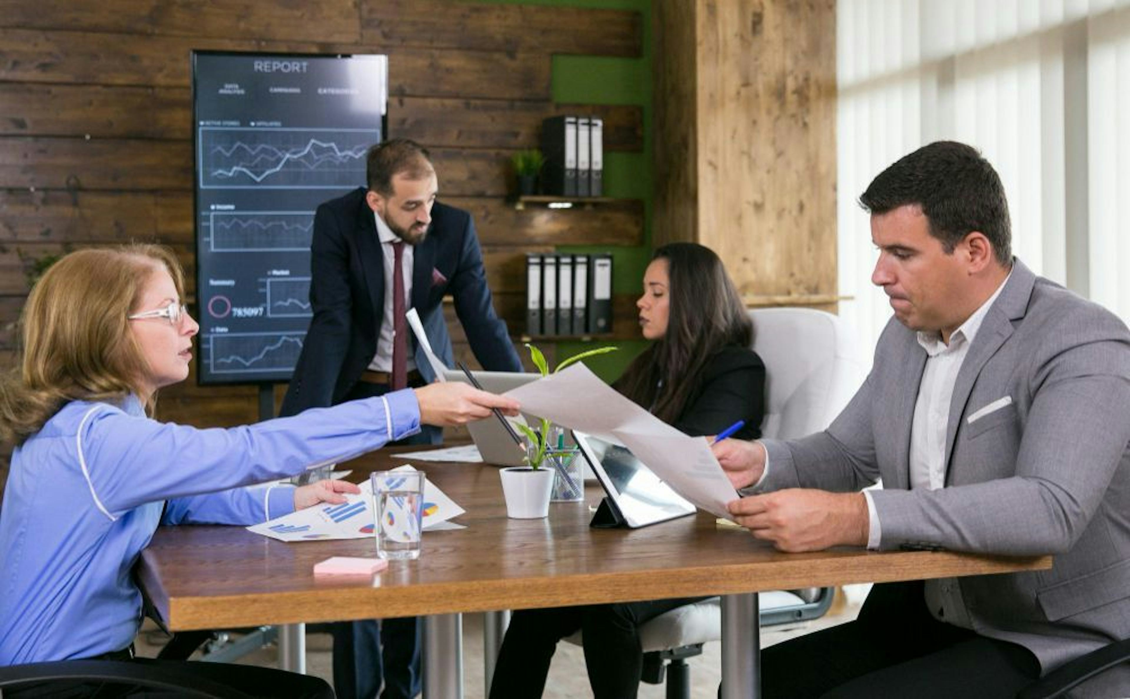 four people working in office environment together