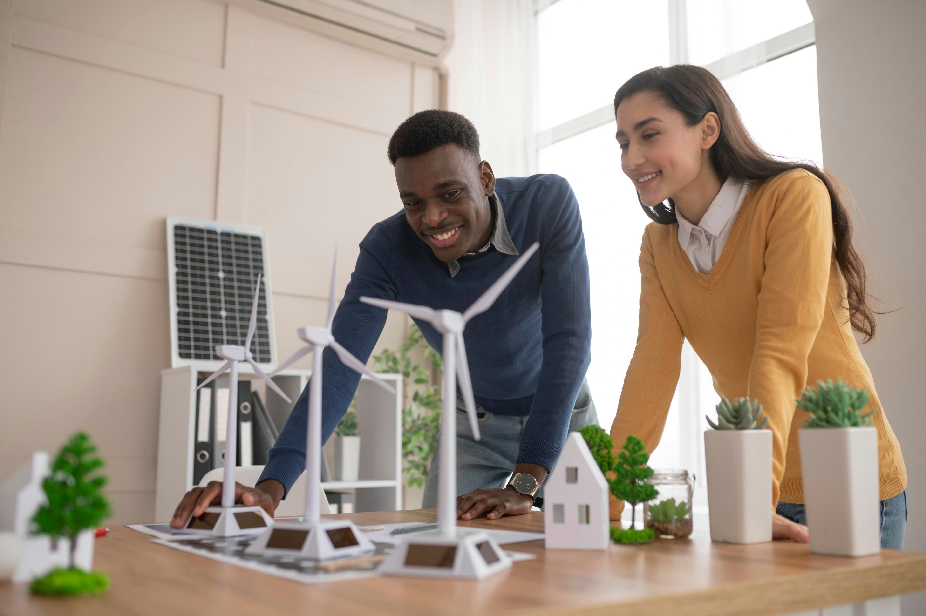 two work colleagues interacting with wind turbine models in an office environment