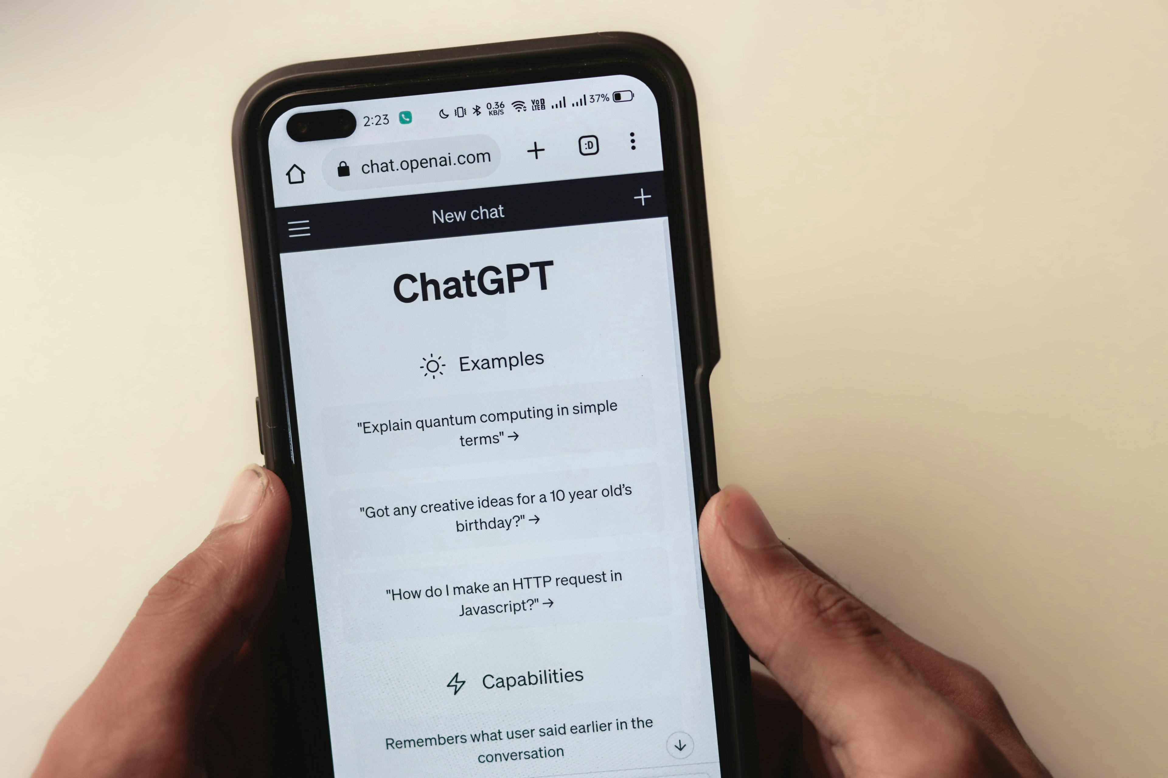 Webpage of ChatGPT, a prototype AI chatbot, is seen on the website of OpenAI, on a smartphone. Examples, capabilities, and limitations are shown in that picture.