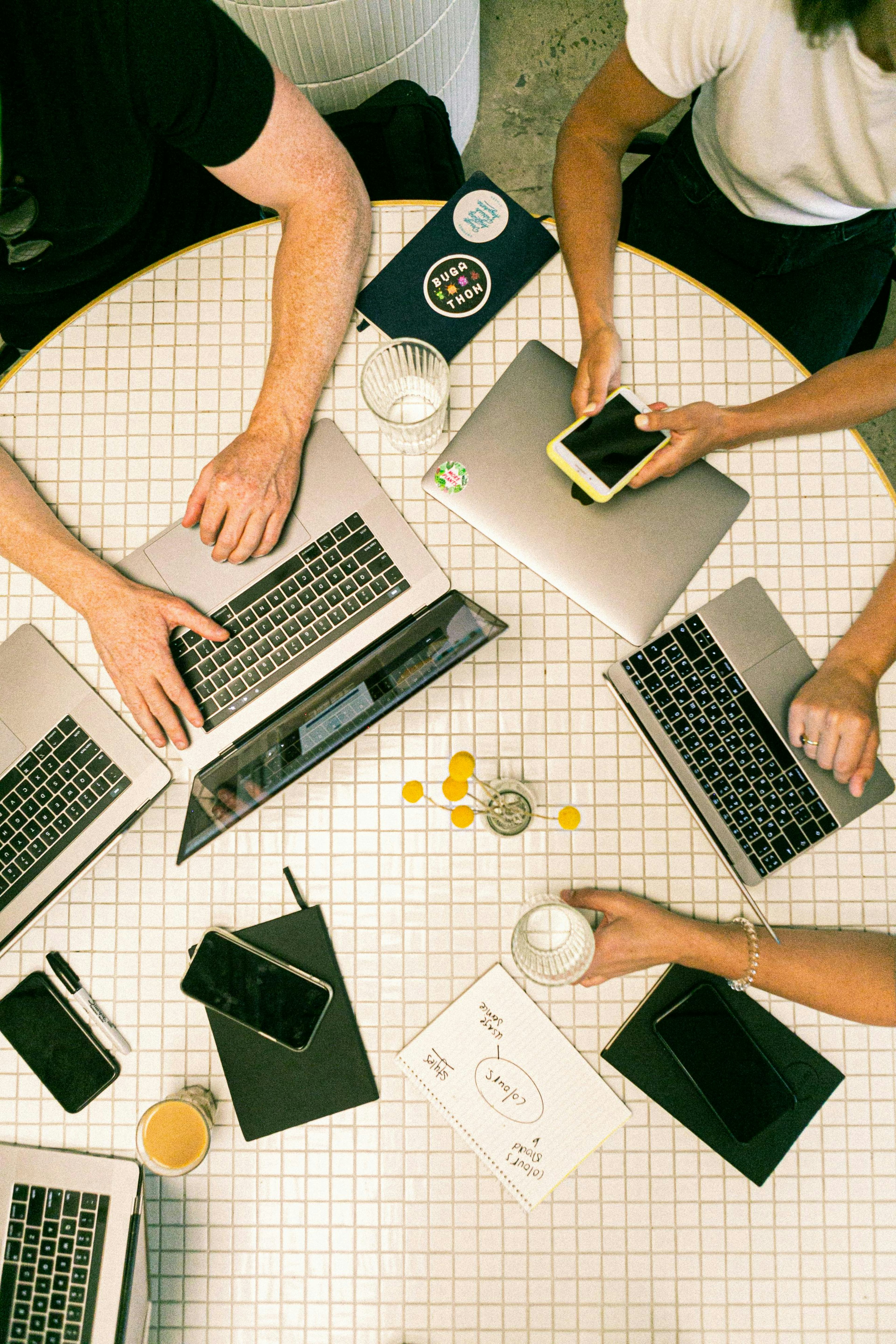 Group of people in a circle on their computers and phones