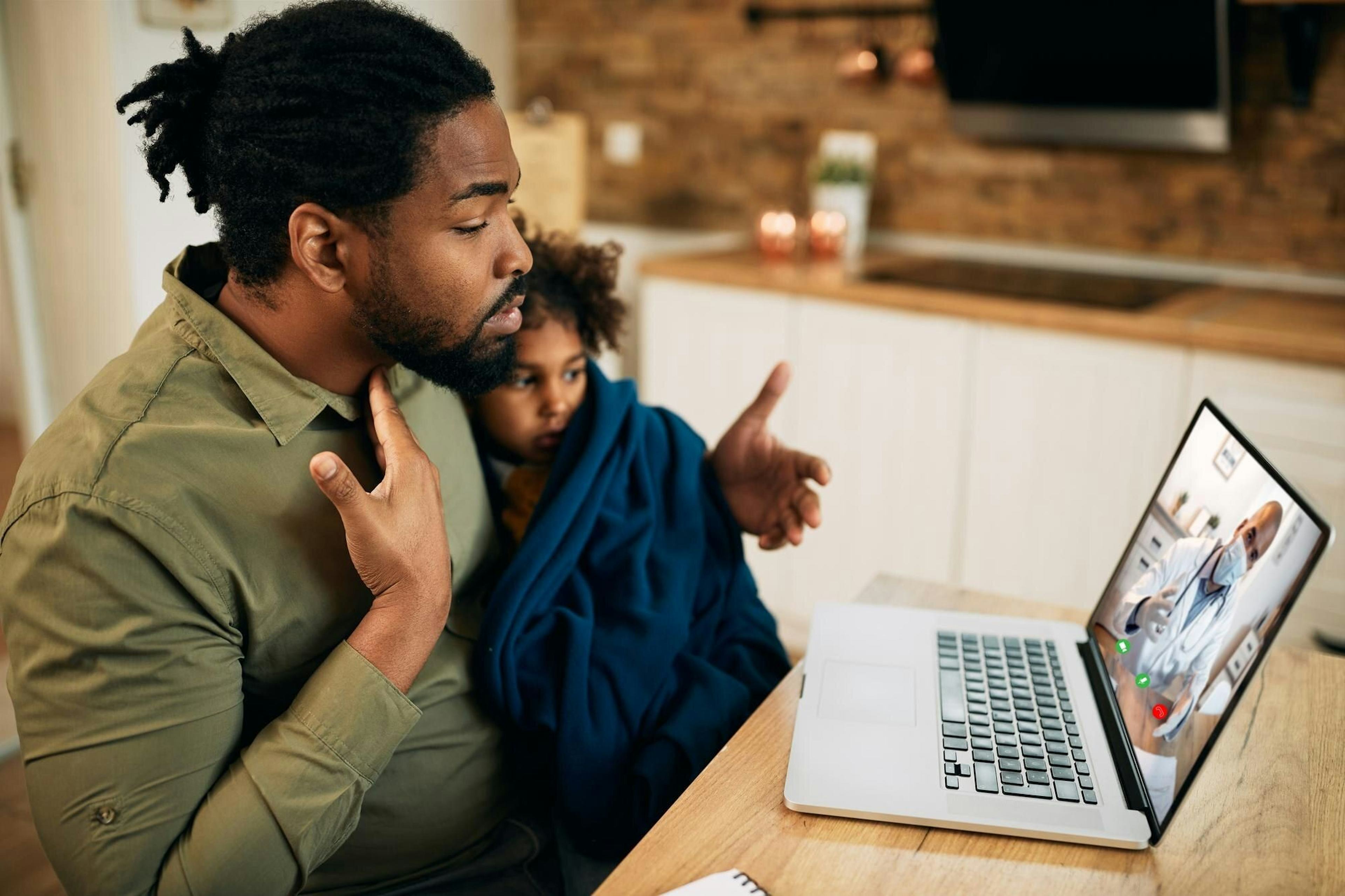 African American father having video call with family doctor while his daughter is feeling unwell