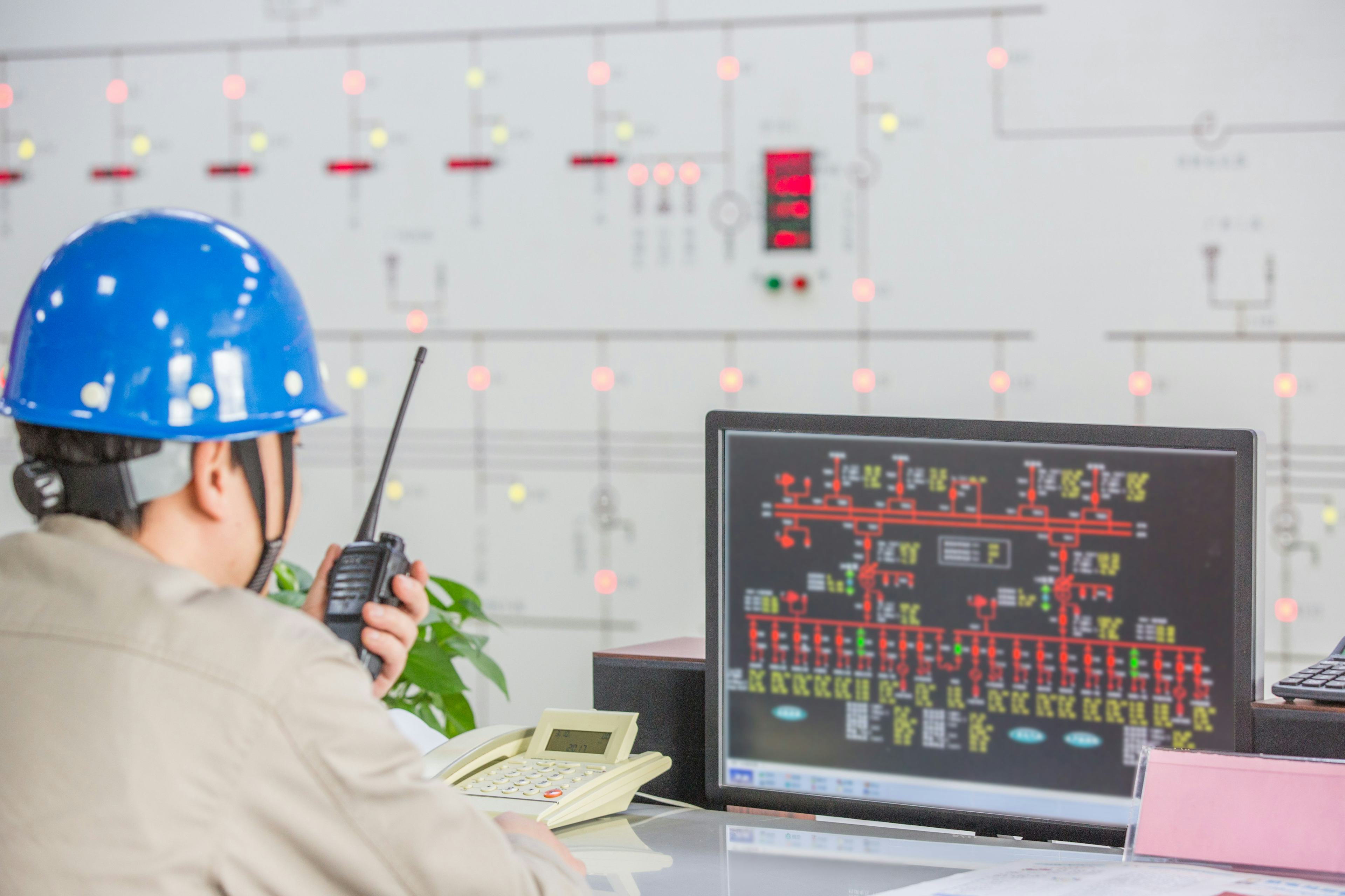 worker wearing hard hat in an energy factory control room