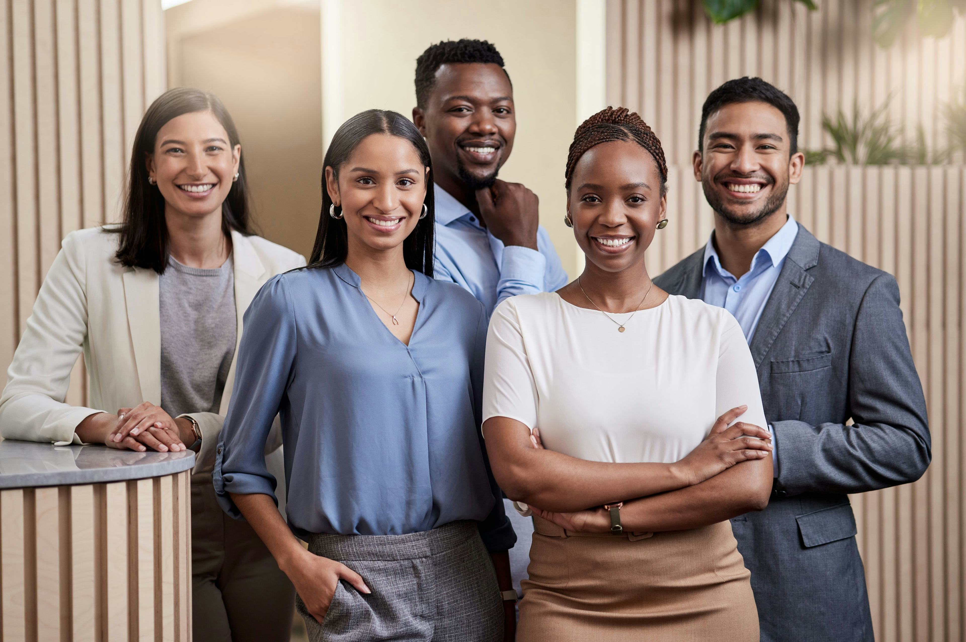 diverse multiracial team of businesspeople together in their office with their arms crossed