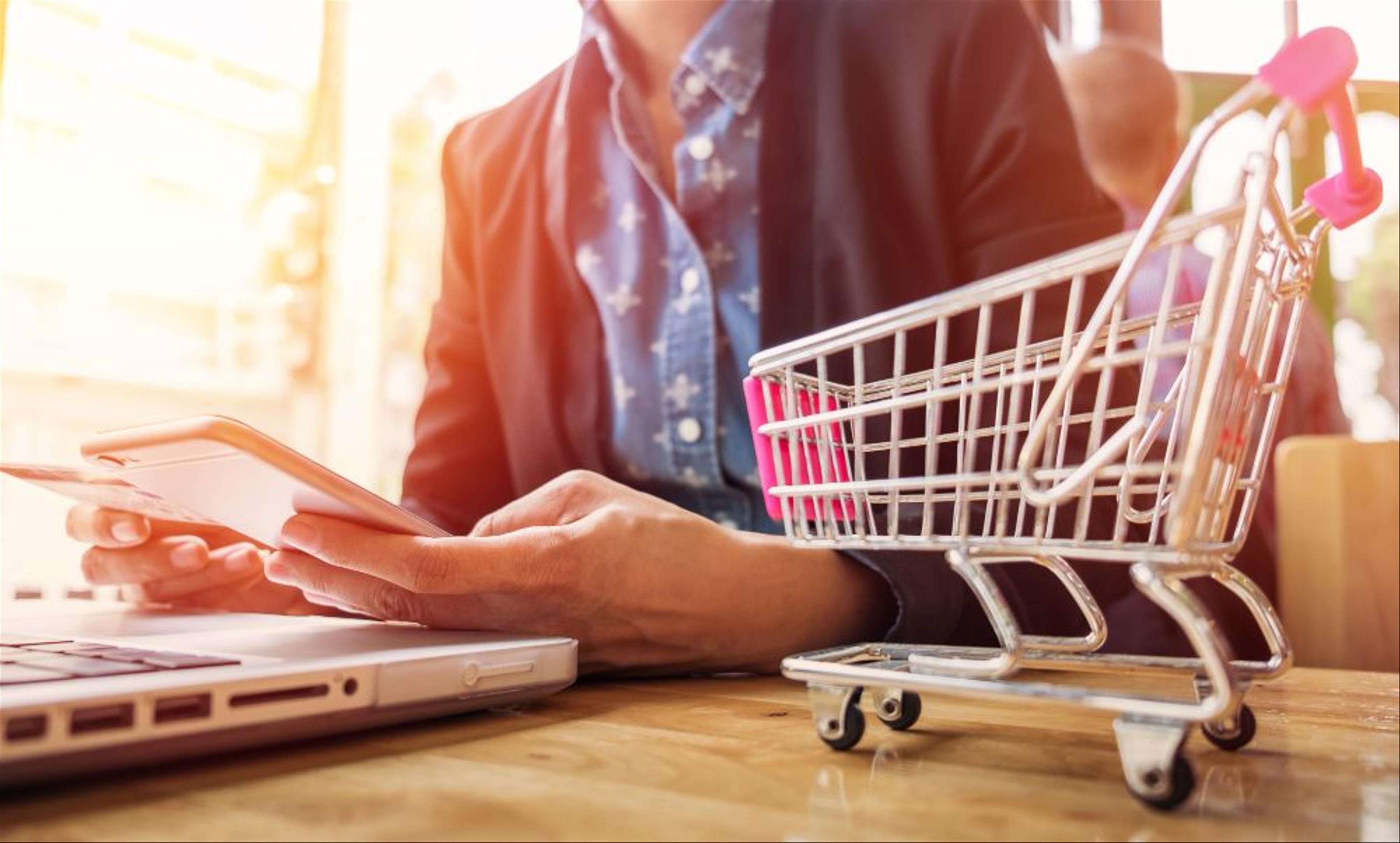 woman using phone and shopping cart toy