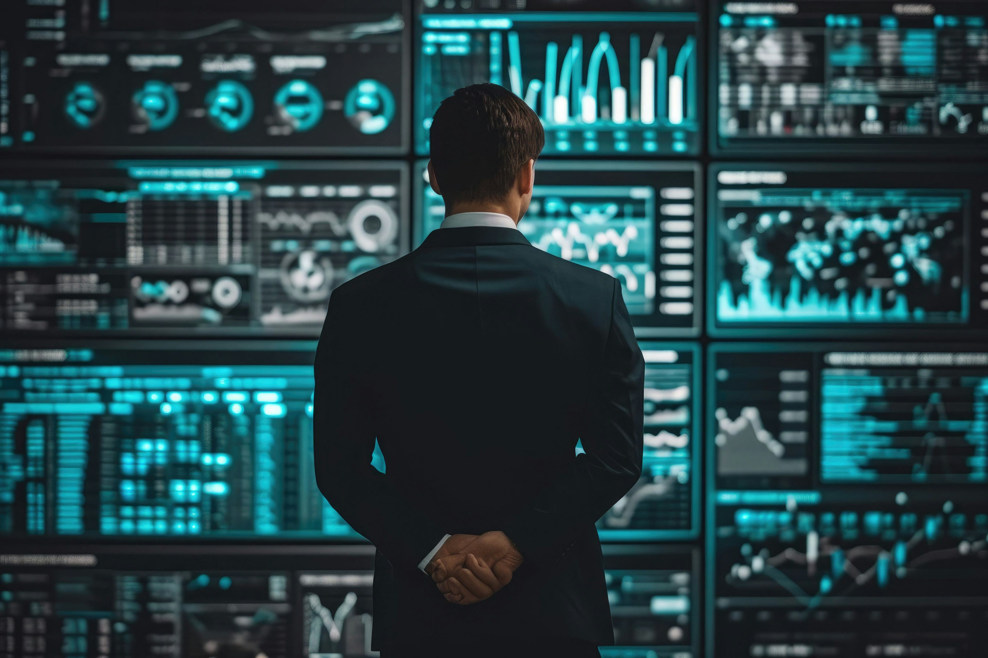 A man looking at multiple data boards