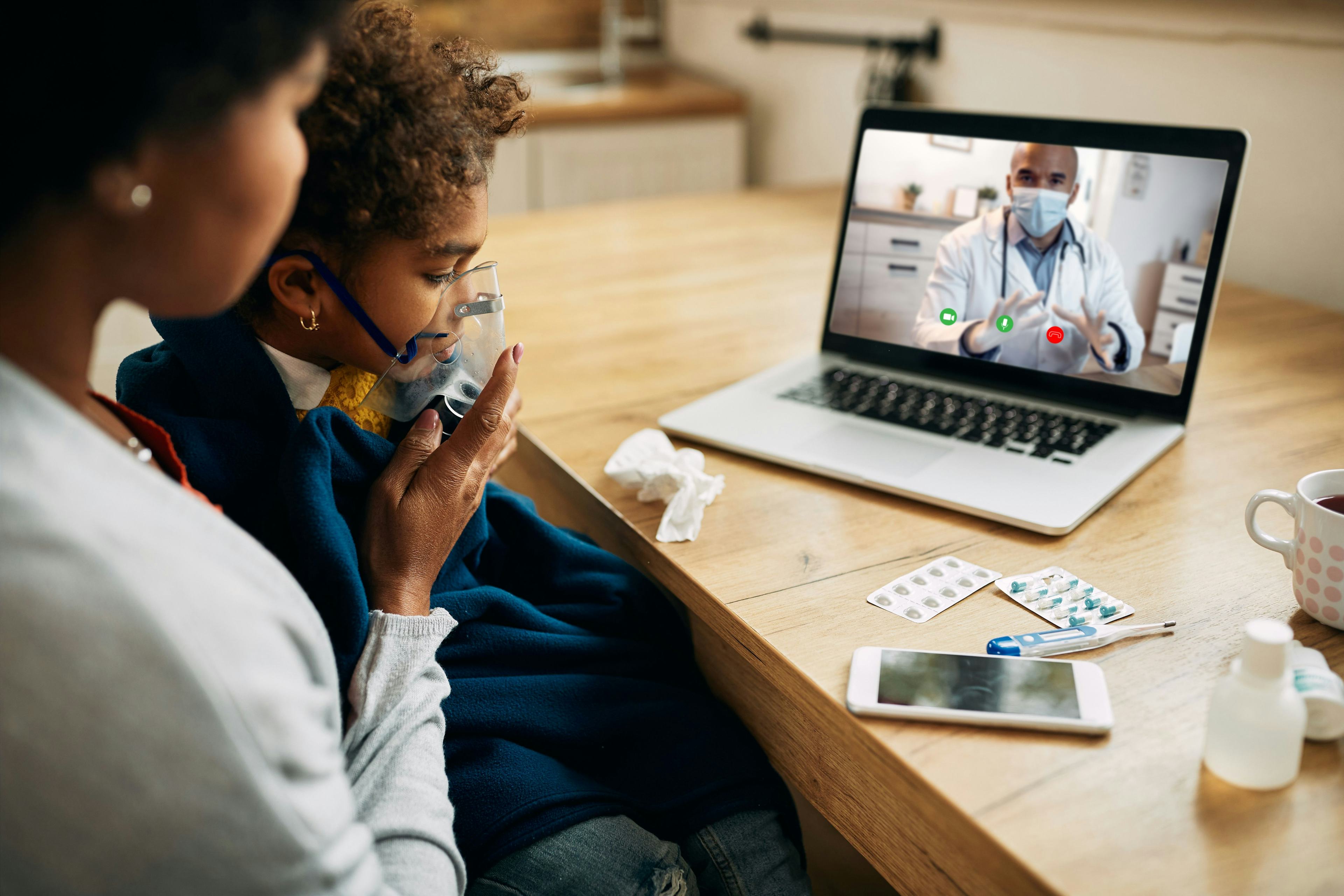 mother and sick child on video call with doctor