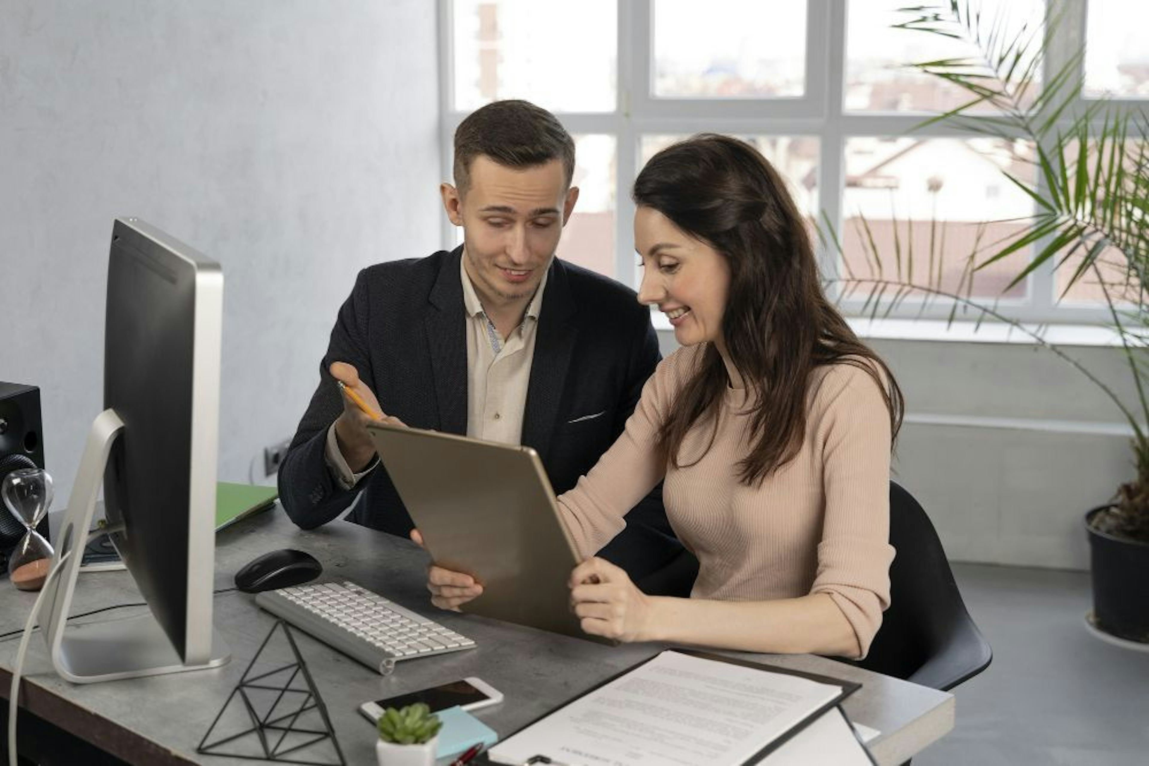 colleagues at work in front of desktop computer