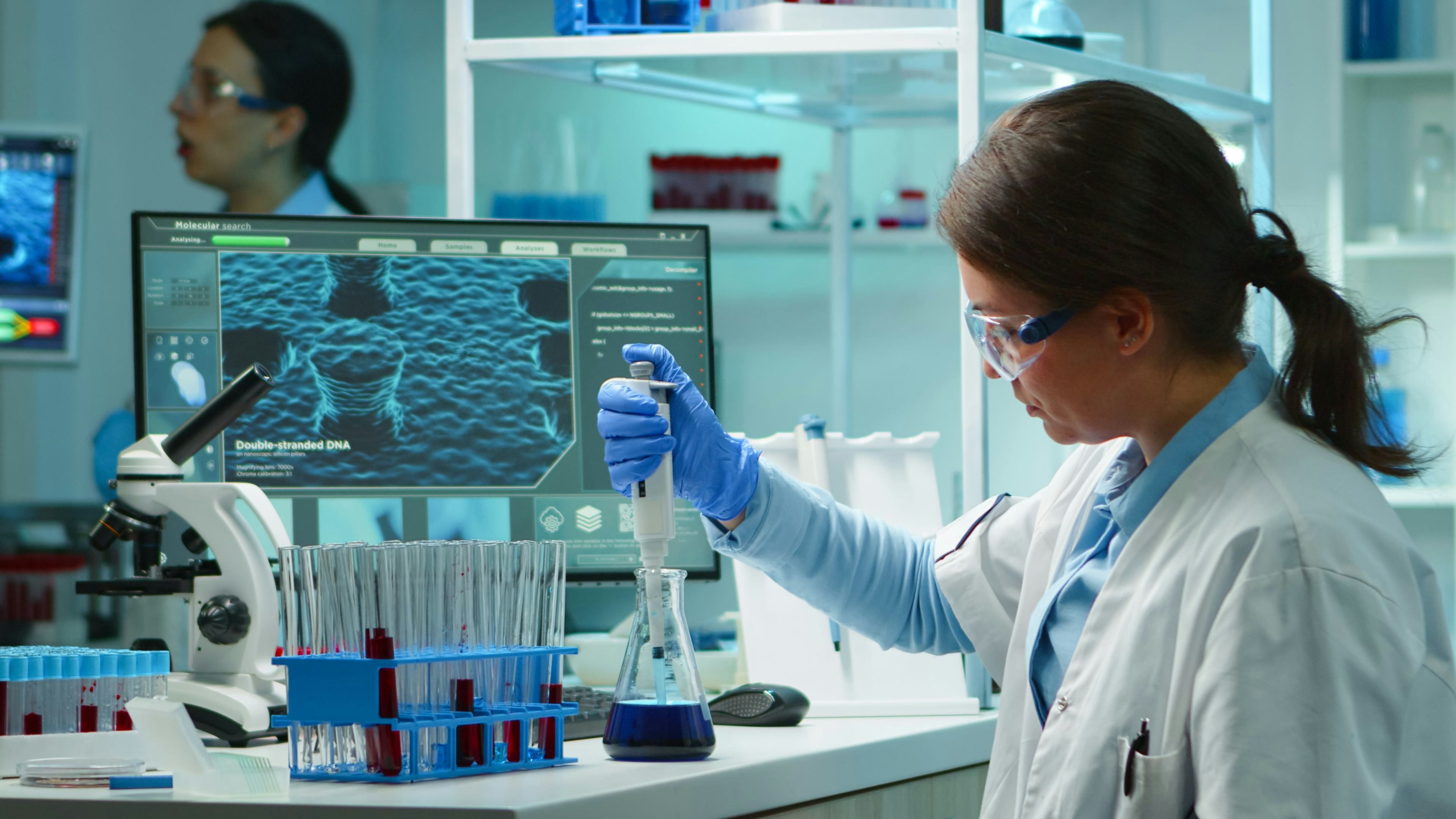 medical professional pipetting liquid into test tube