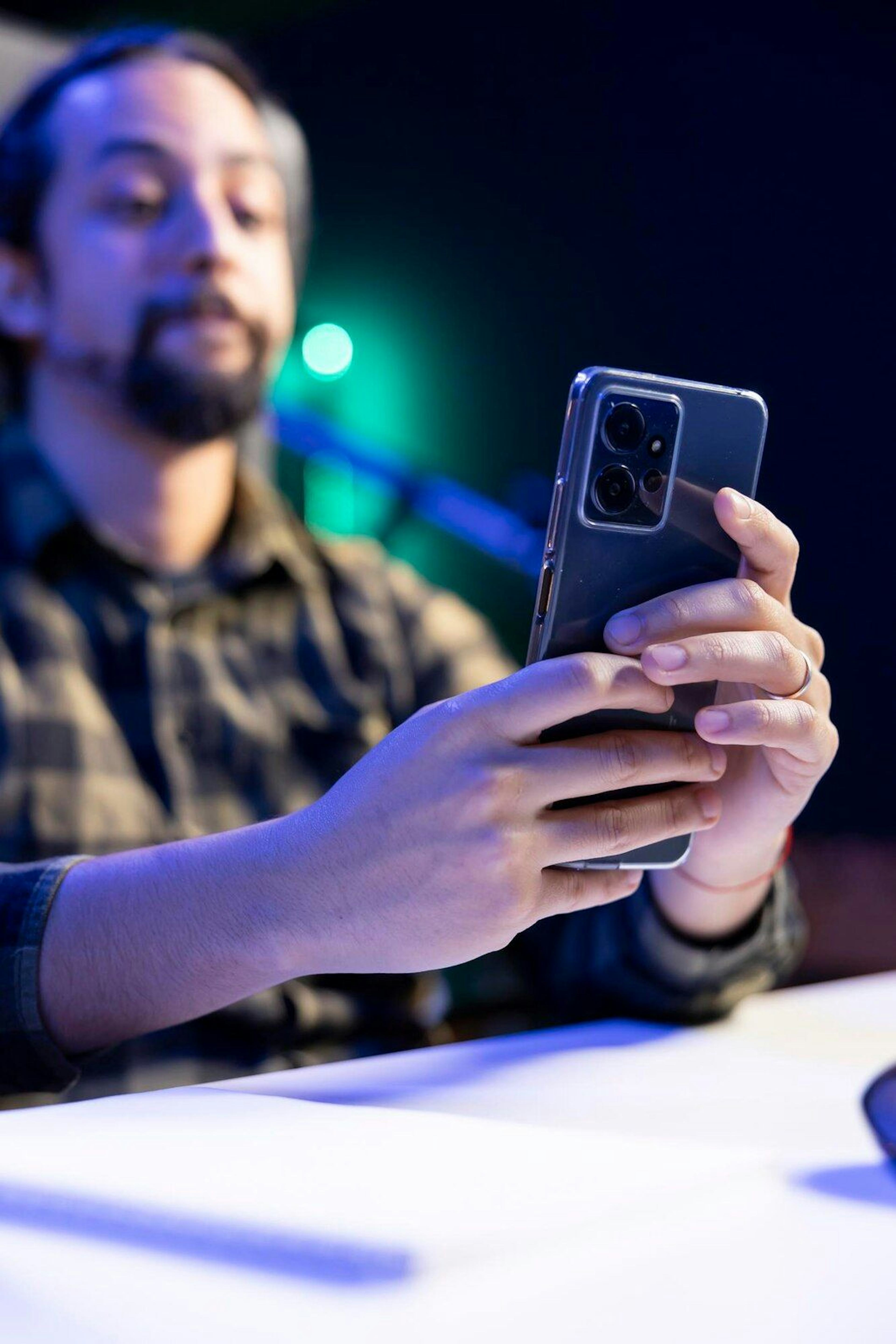 man holding and looking at screen of mobile phone