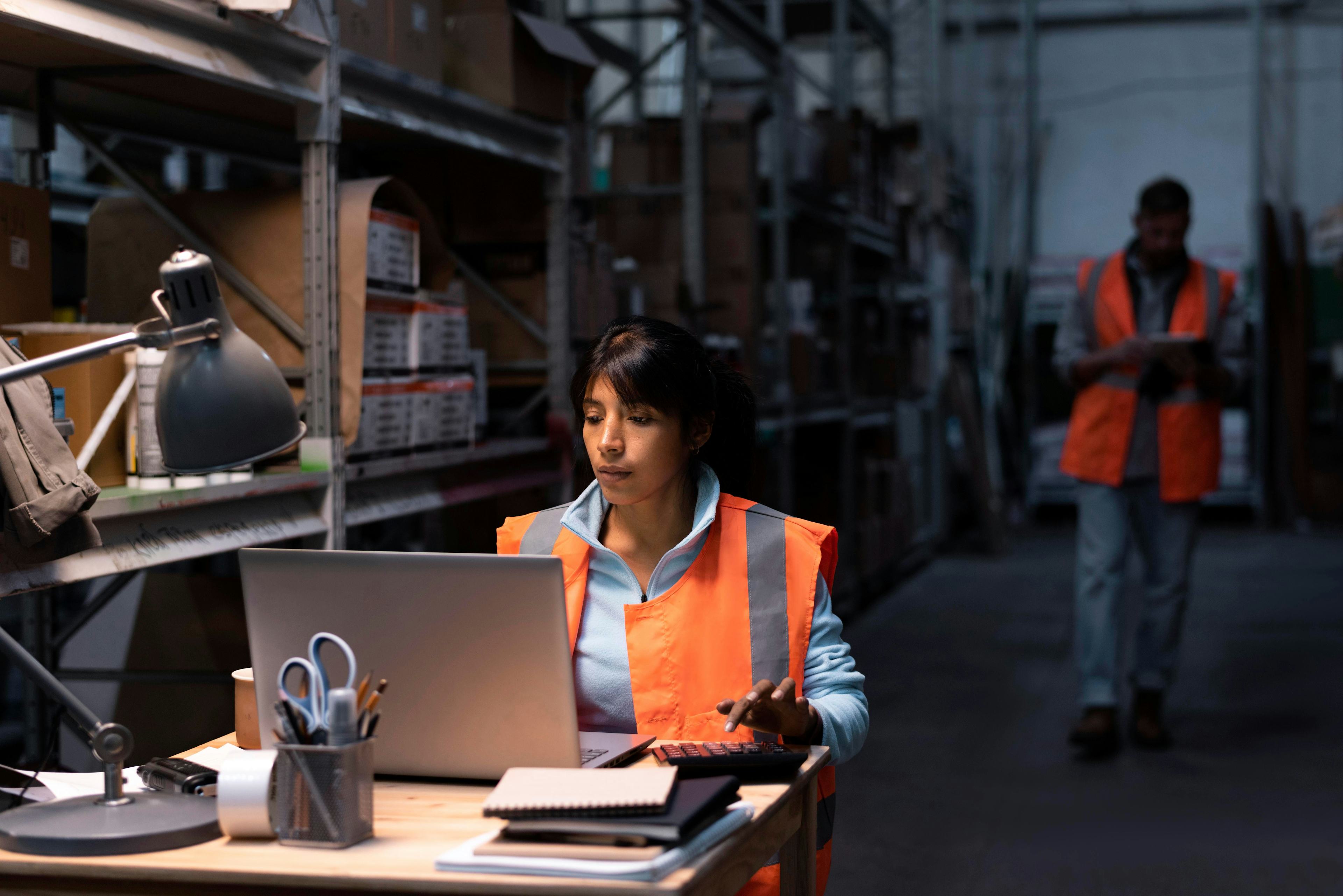 Woman working on computer in warehouse