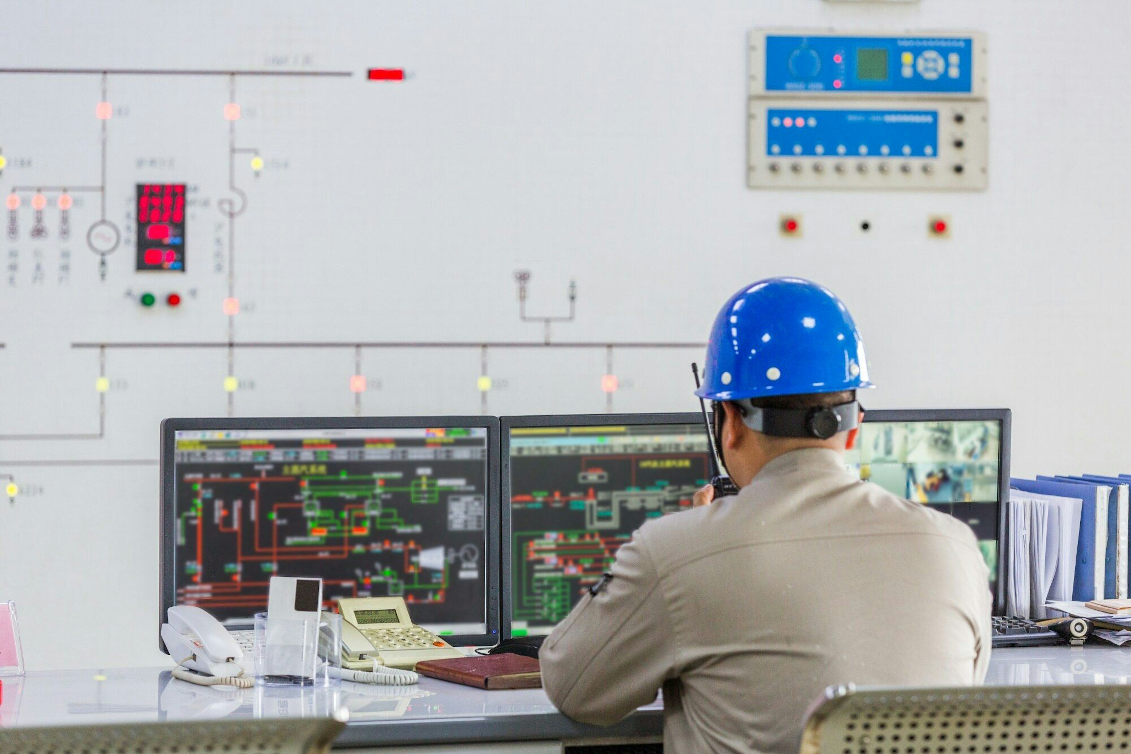 worker wearing hard hat in control room