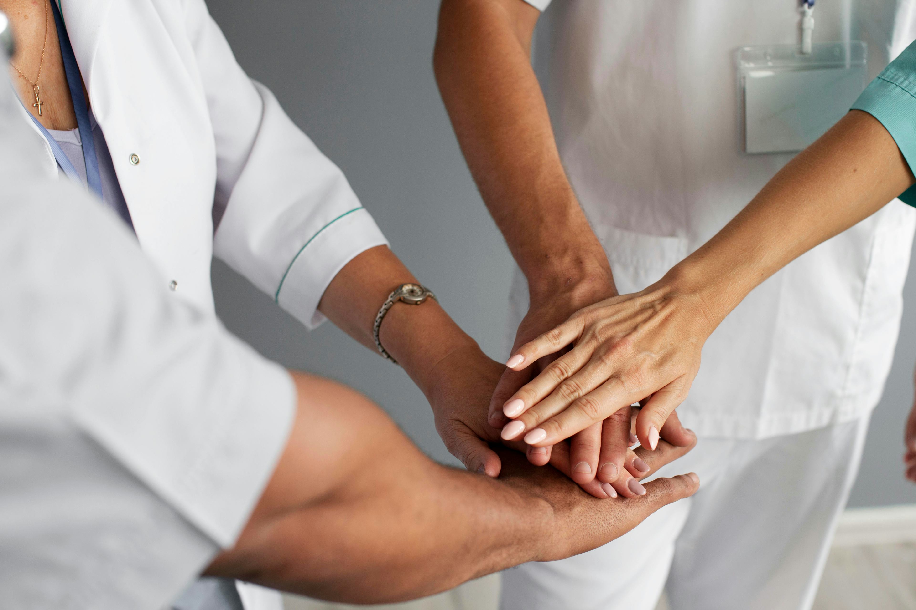 Close up on team of health workers' hands