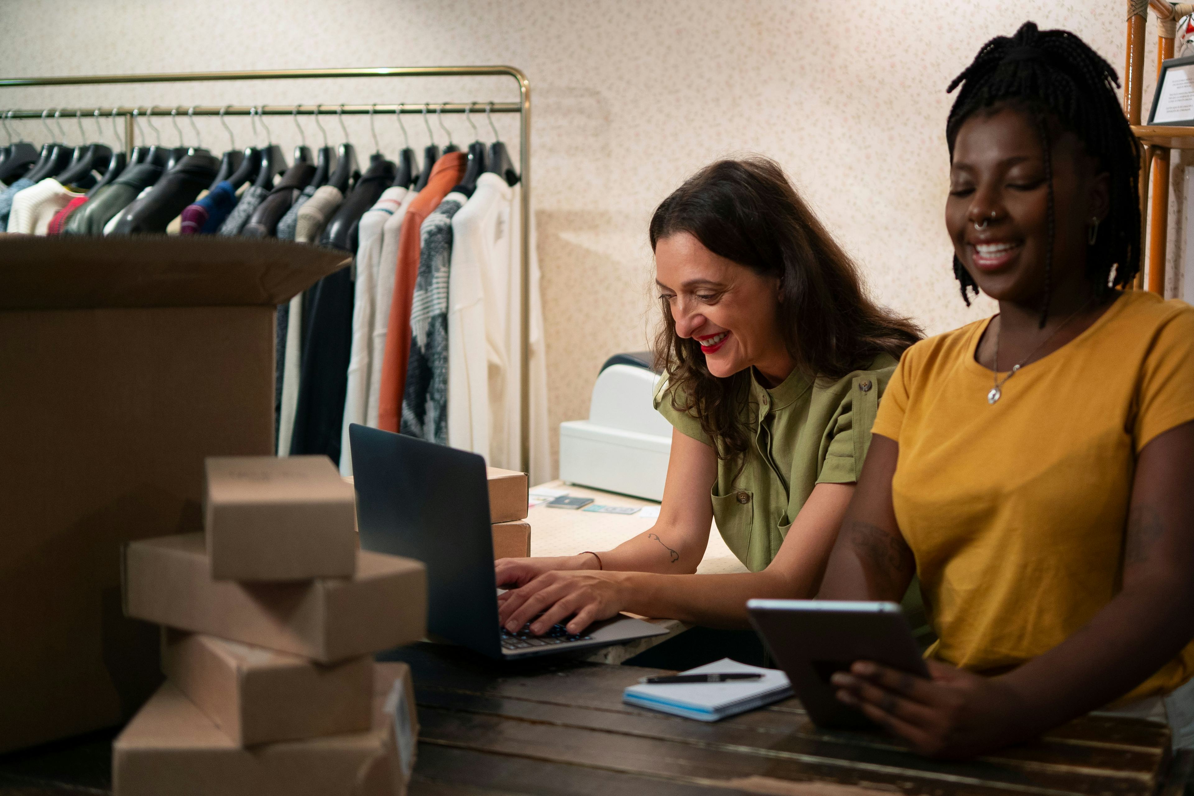 Two women managing their e-commerce business enjoyably in their store