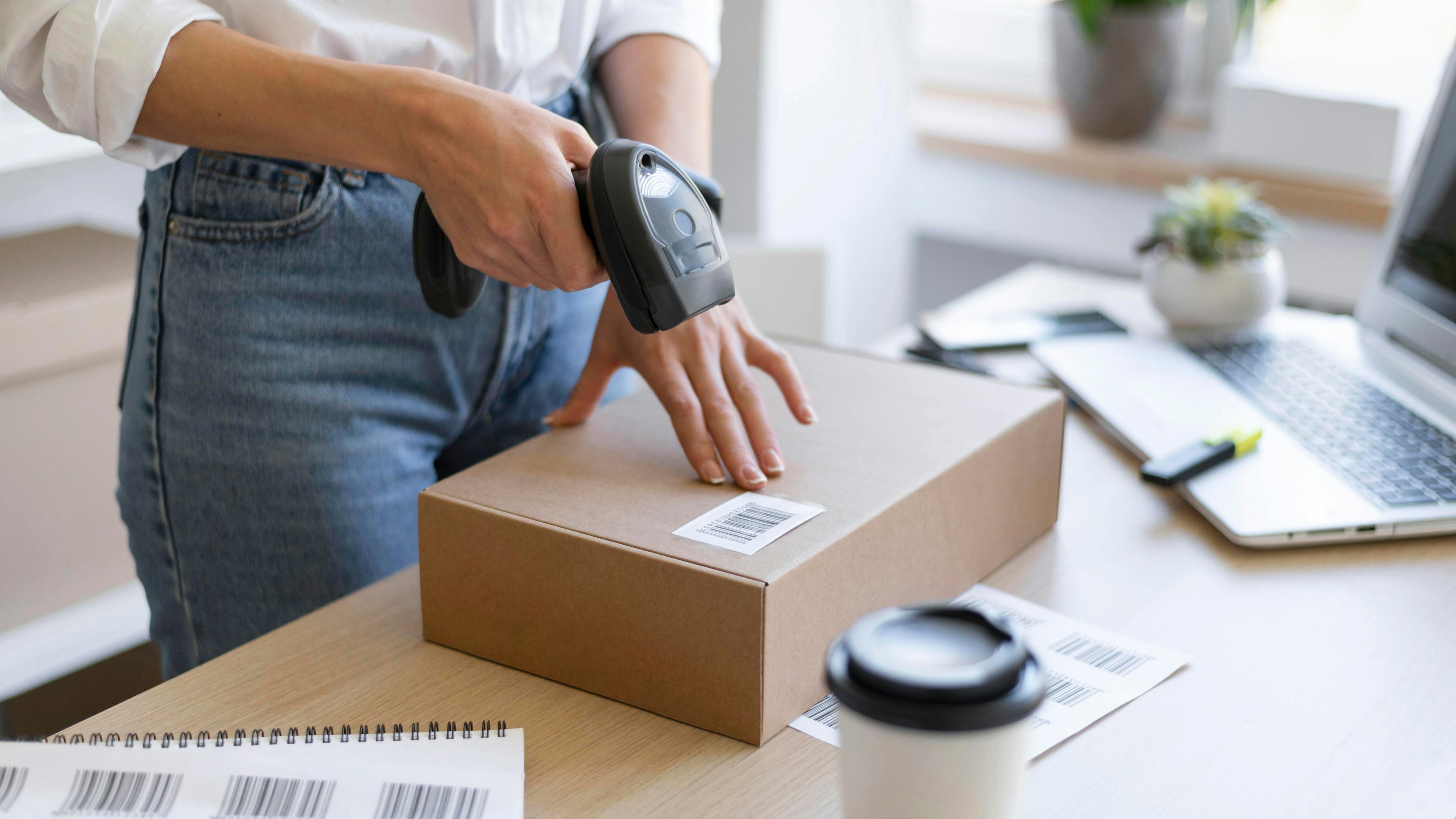 close up hand holding scanner over package