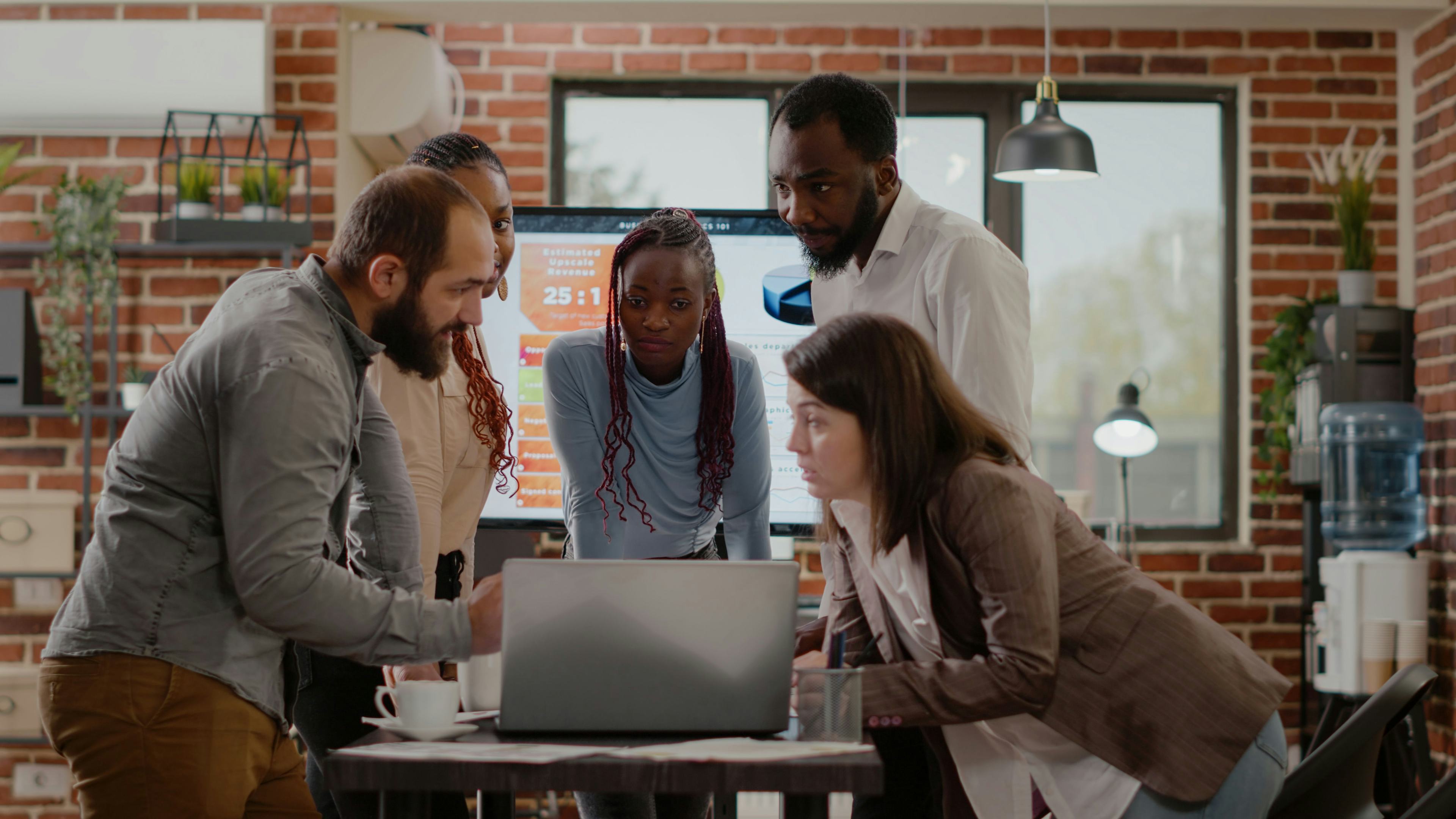 marketing team surrounding laptop during meeting