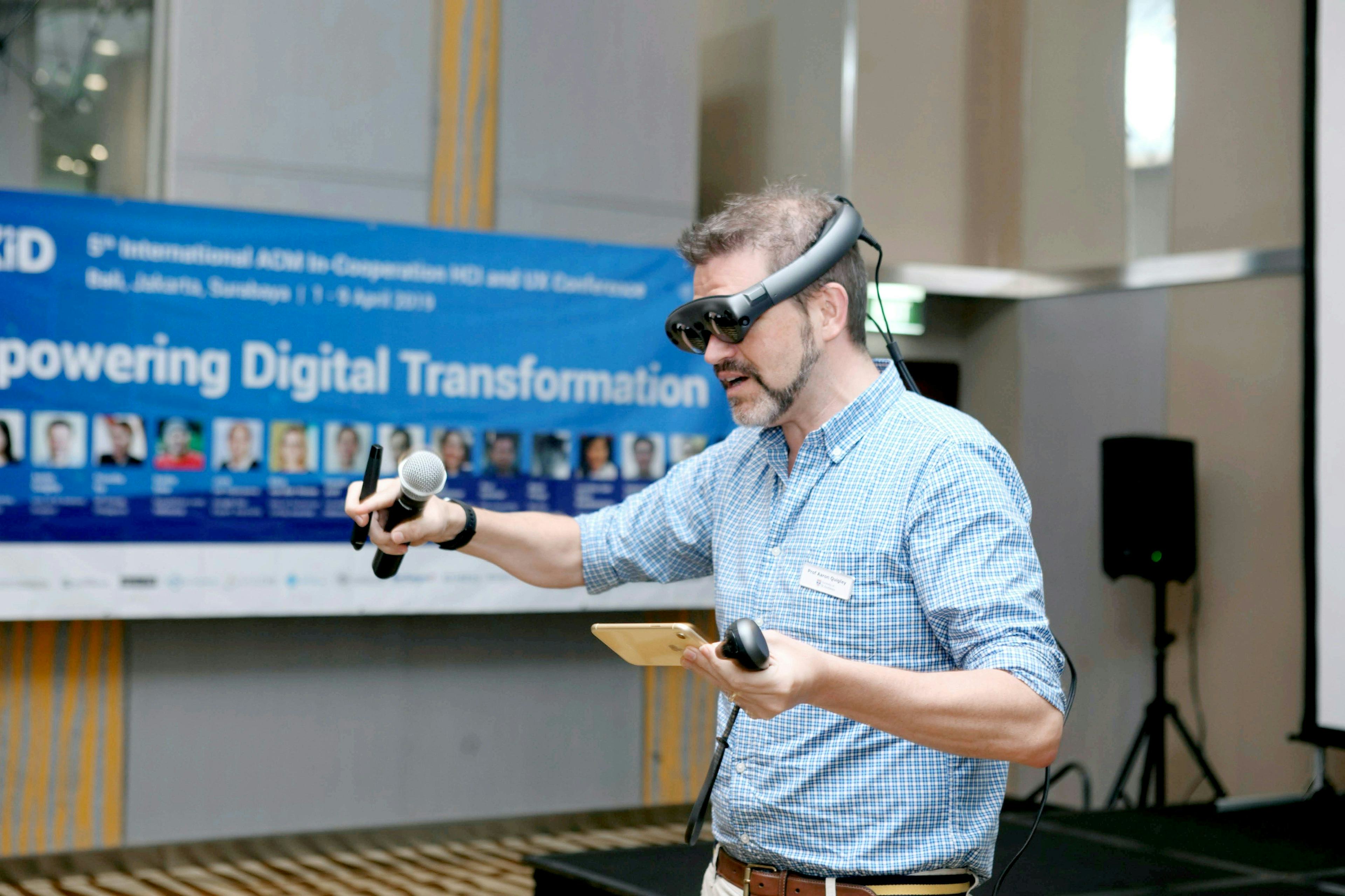 Man wearing a VR headset while holding microphone at digital trnsformtion conference event