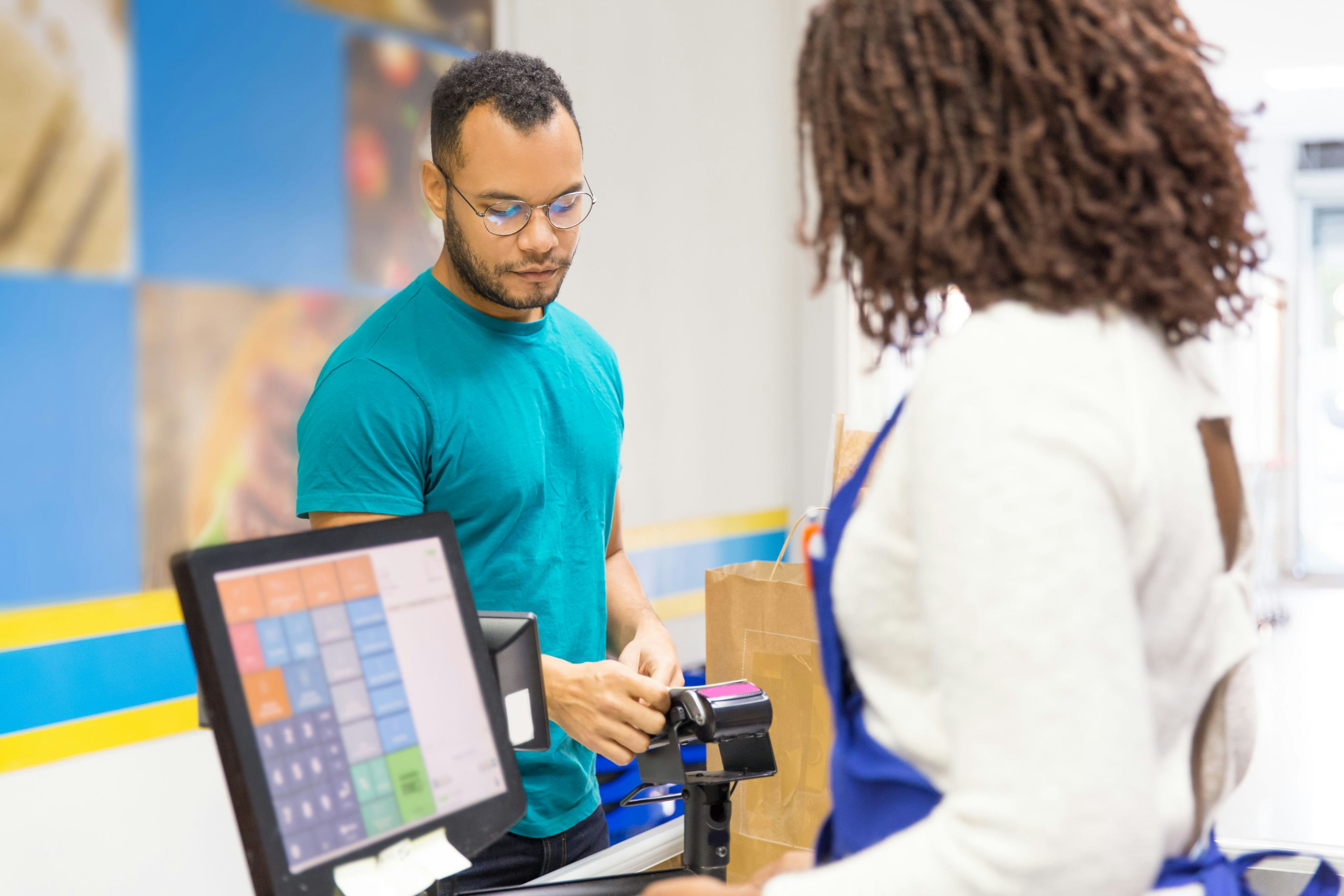 cashier helping a customer at a register 