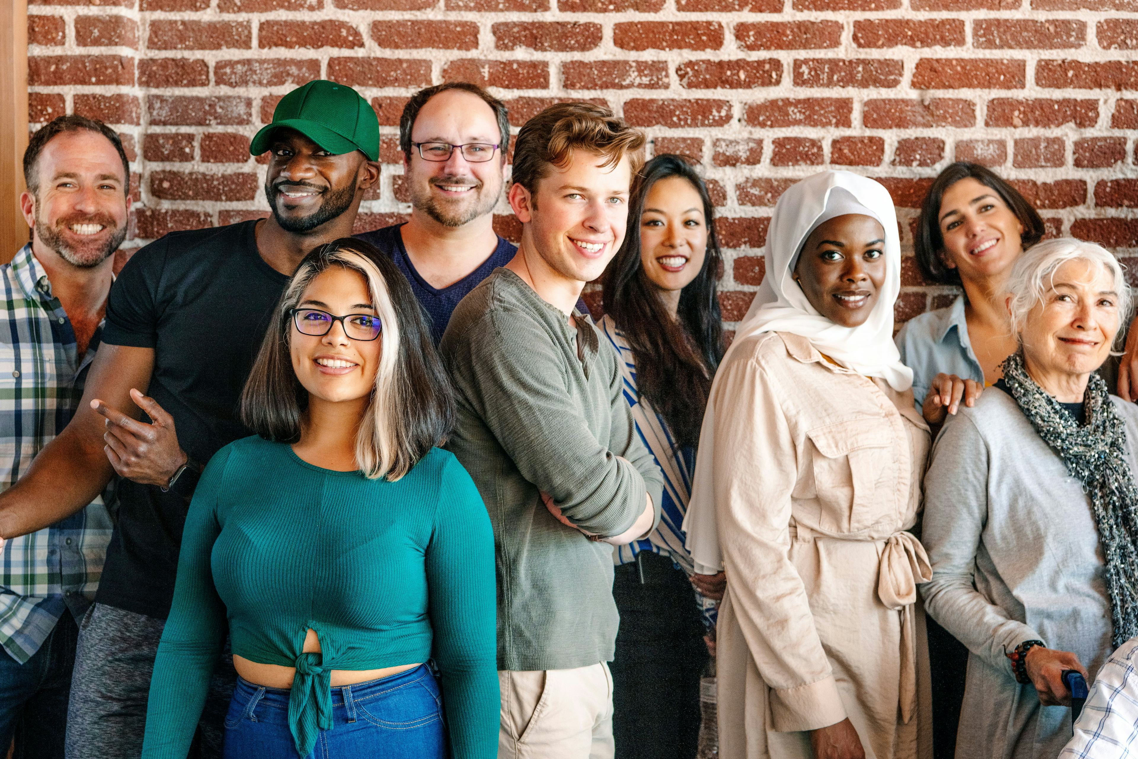 diverse multiracial group of people posing for photo in brightly lit environment