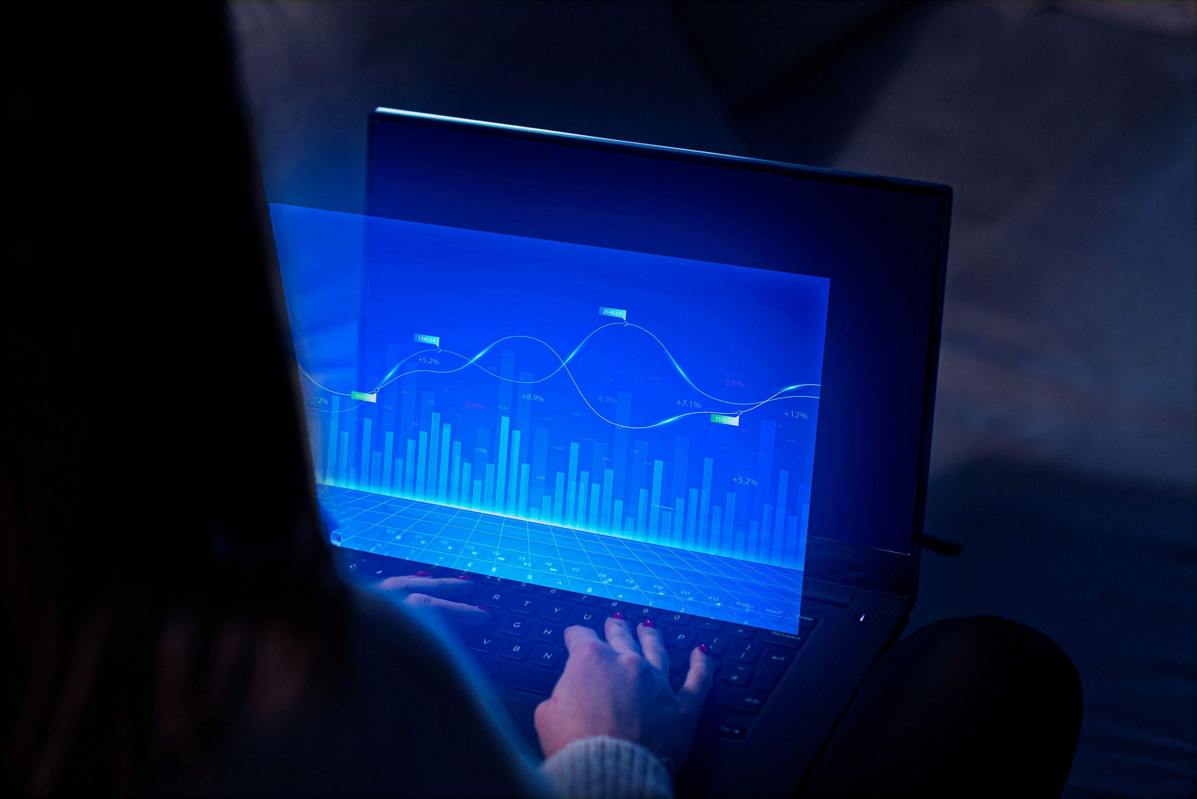 woman viewing blue graph on laptop