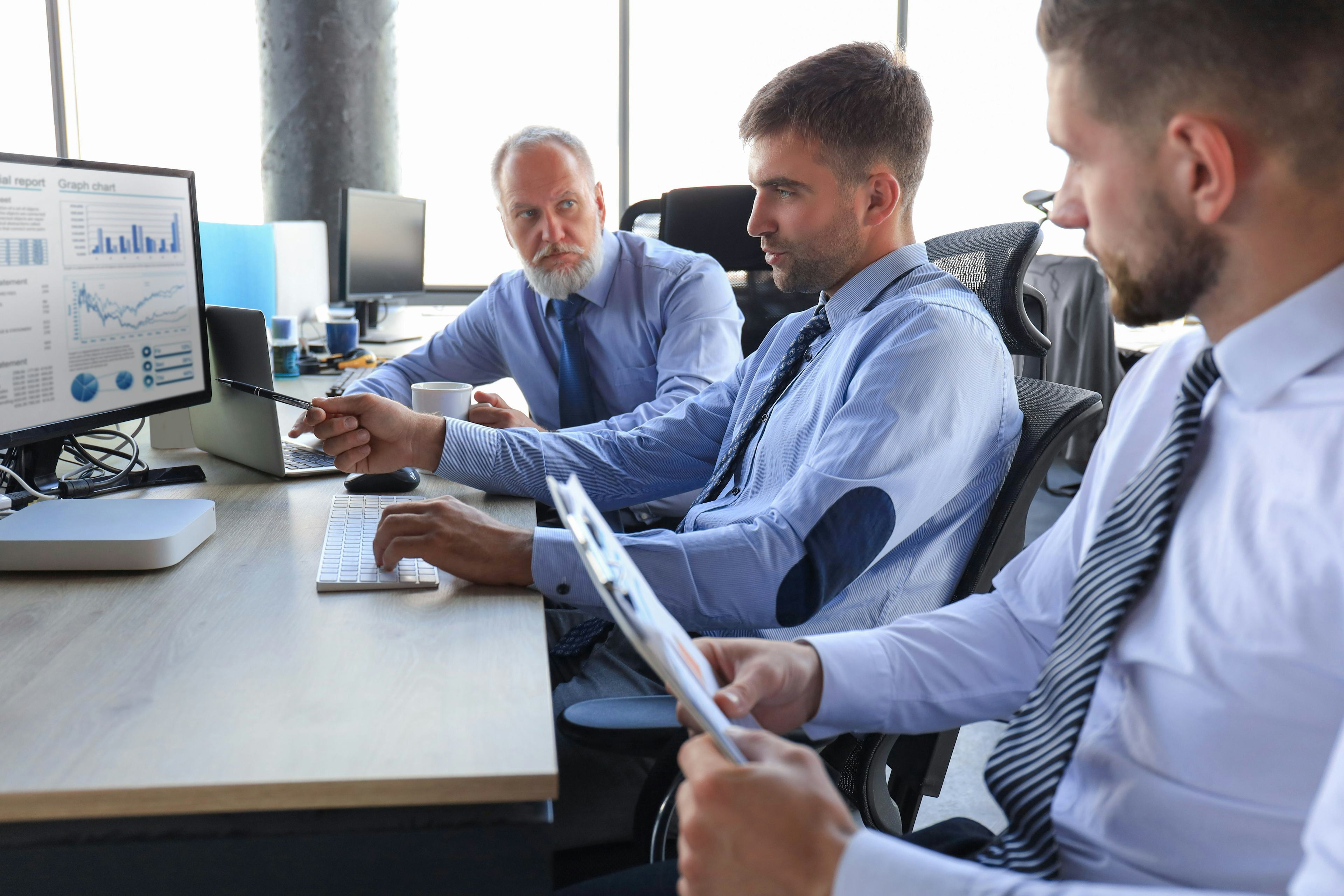 professional businessmen working together in an office environment with an active desktop up