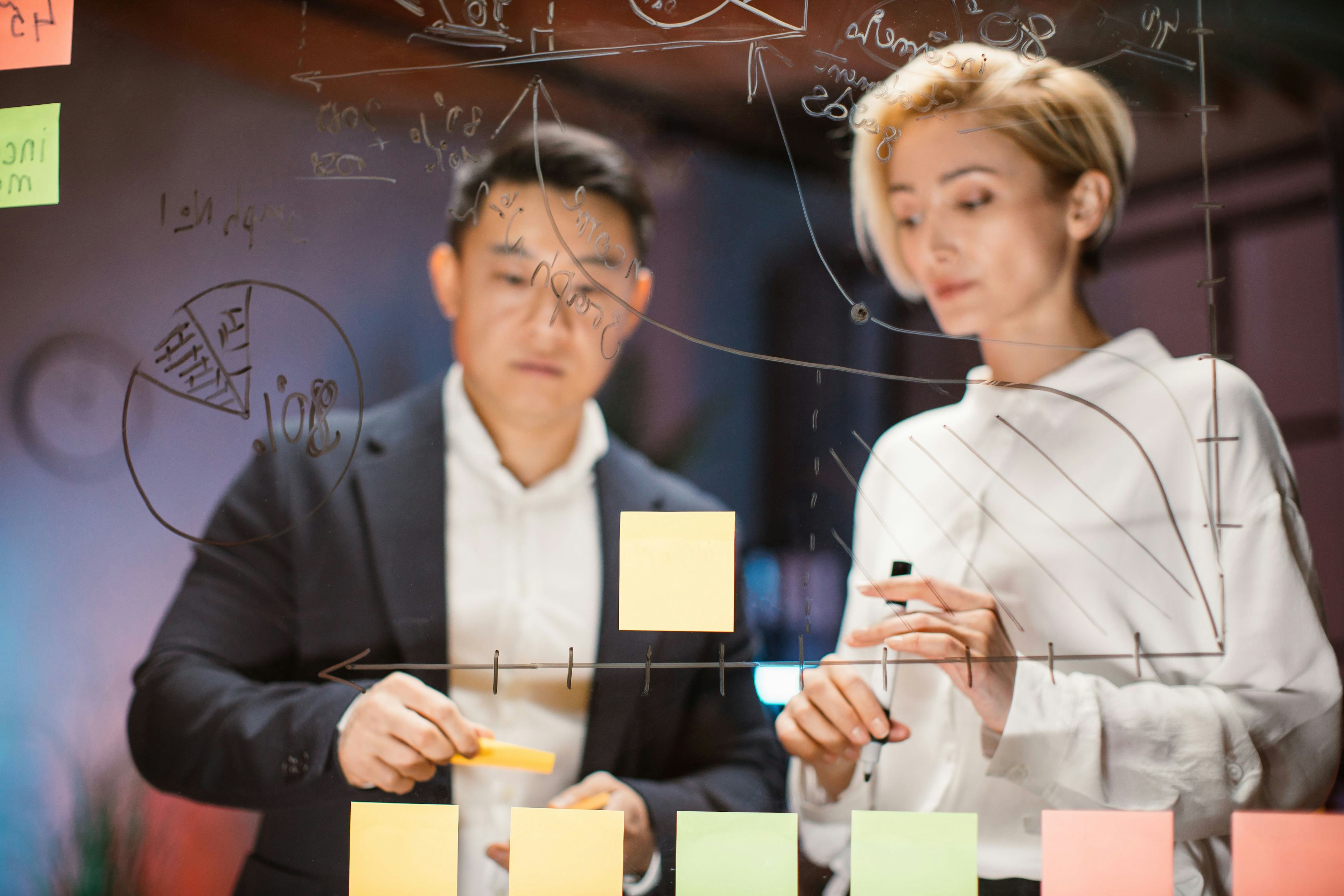 A man and woman working on a whiteboard