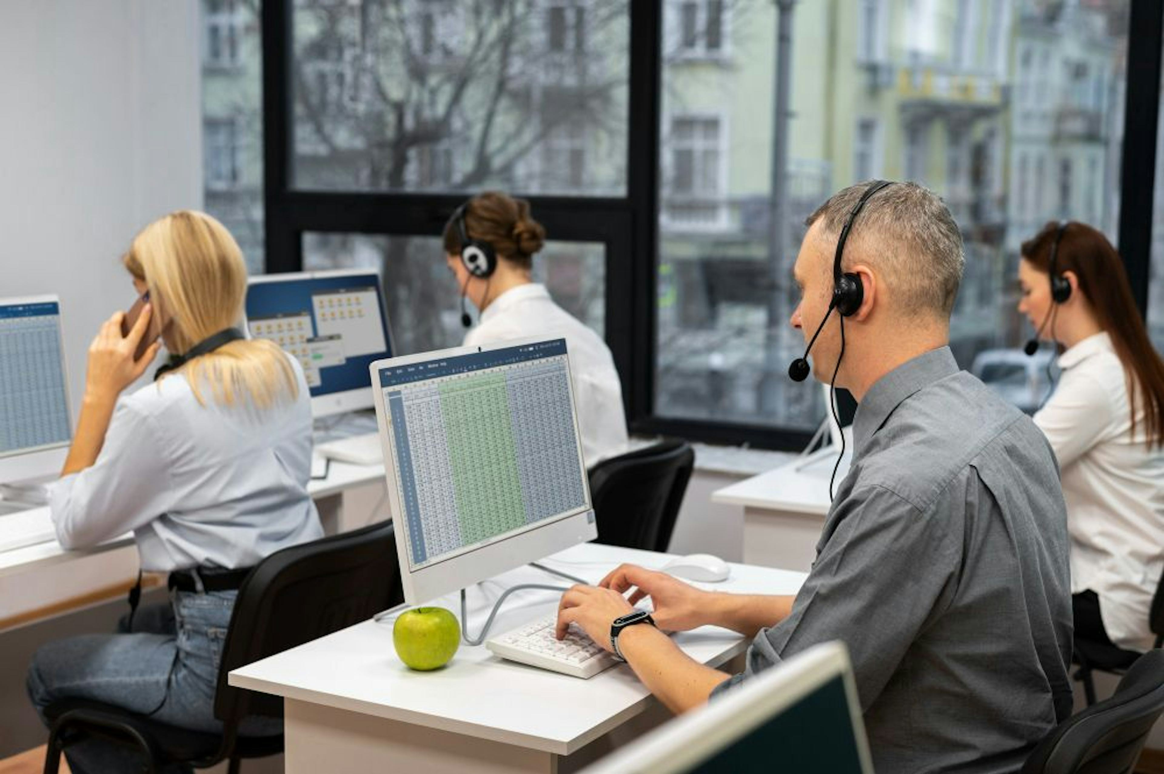 Colleagues wearing headphones working together