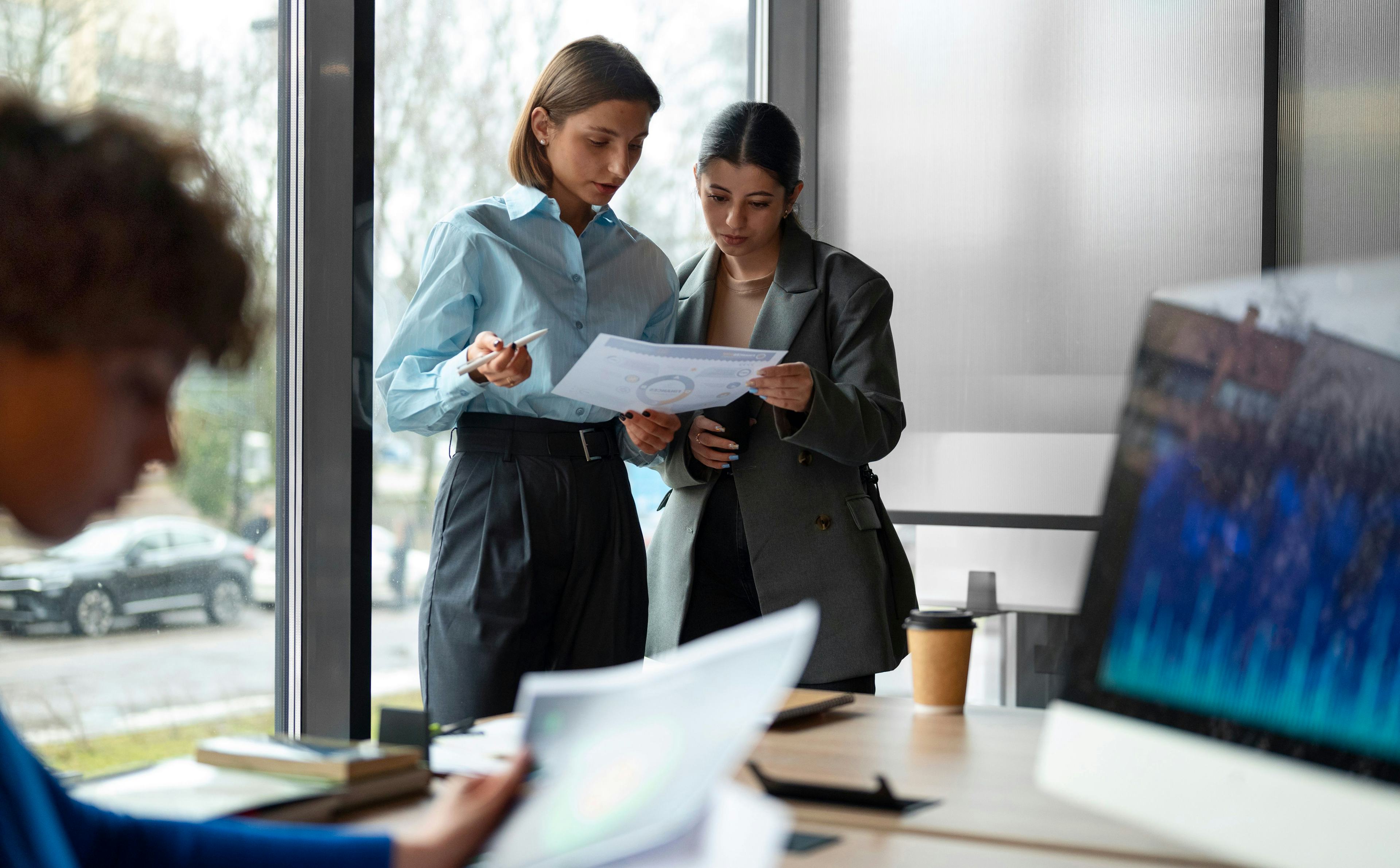 office workers looking at data on paper and computer