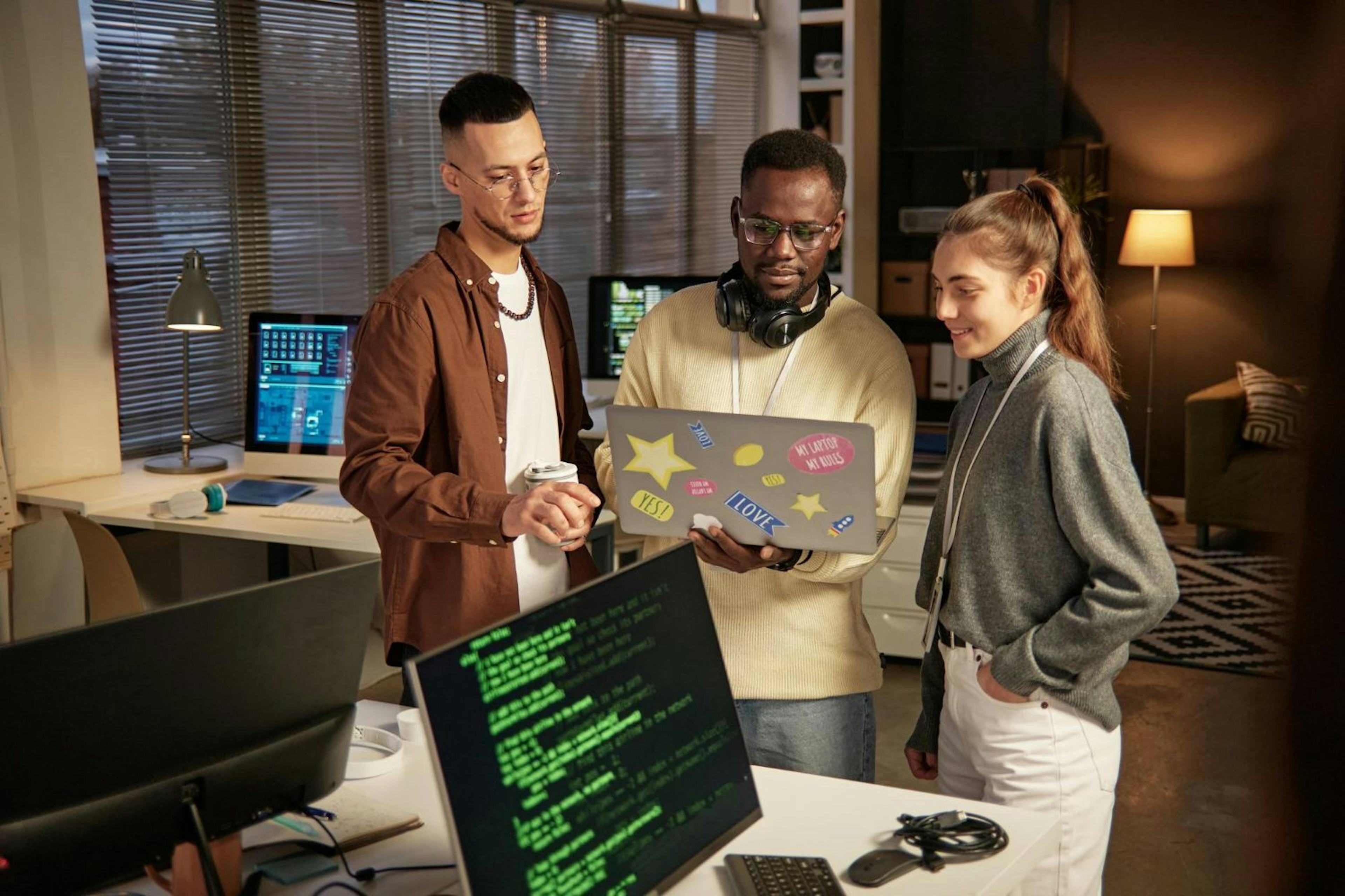 three people discussing on laptop