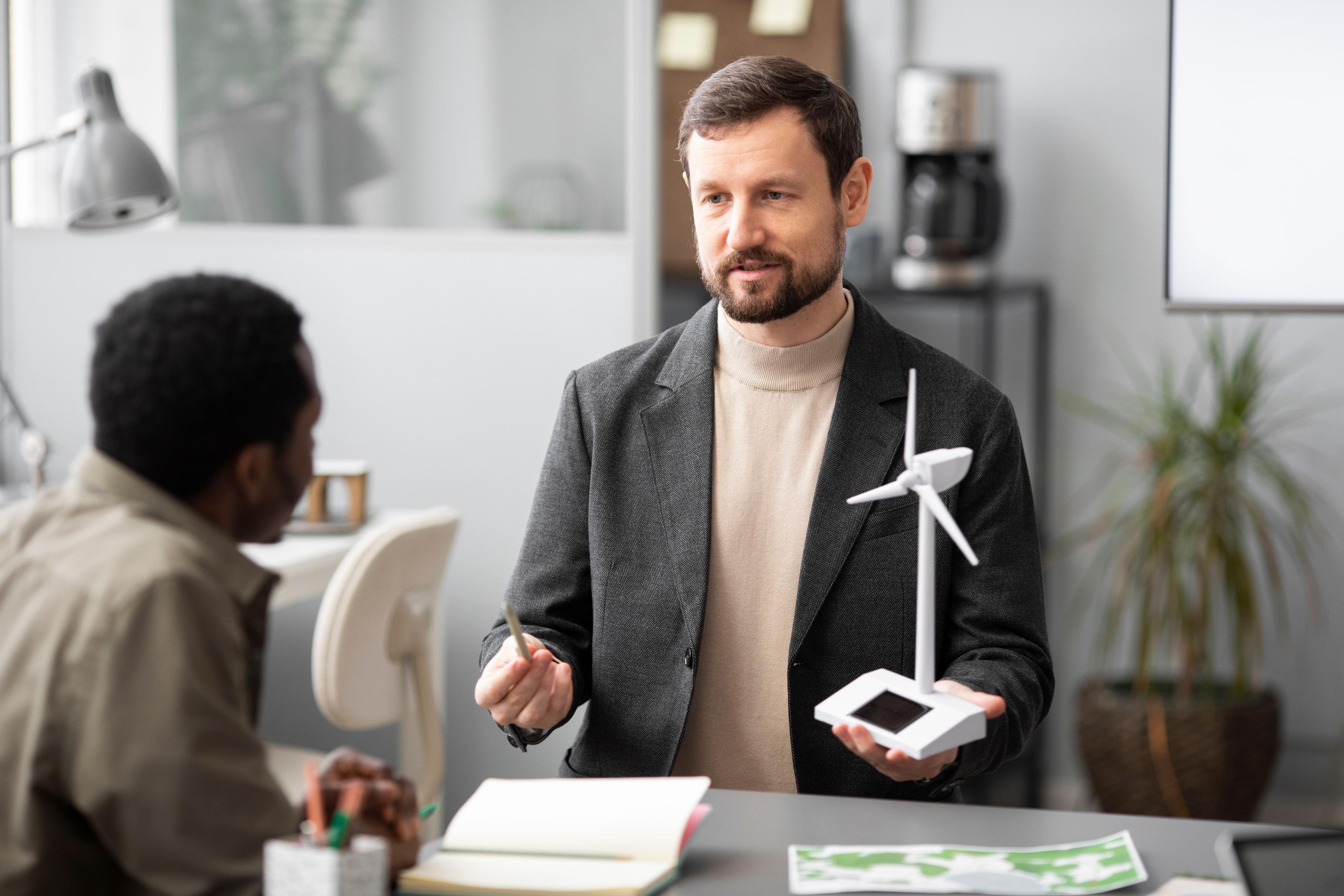 professional holding a wind turbine model in hand