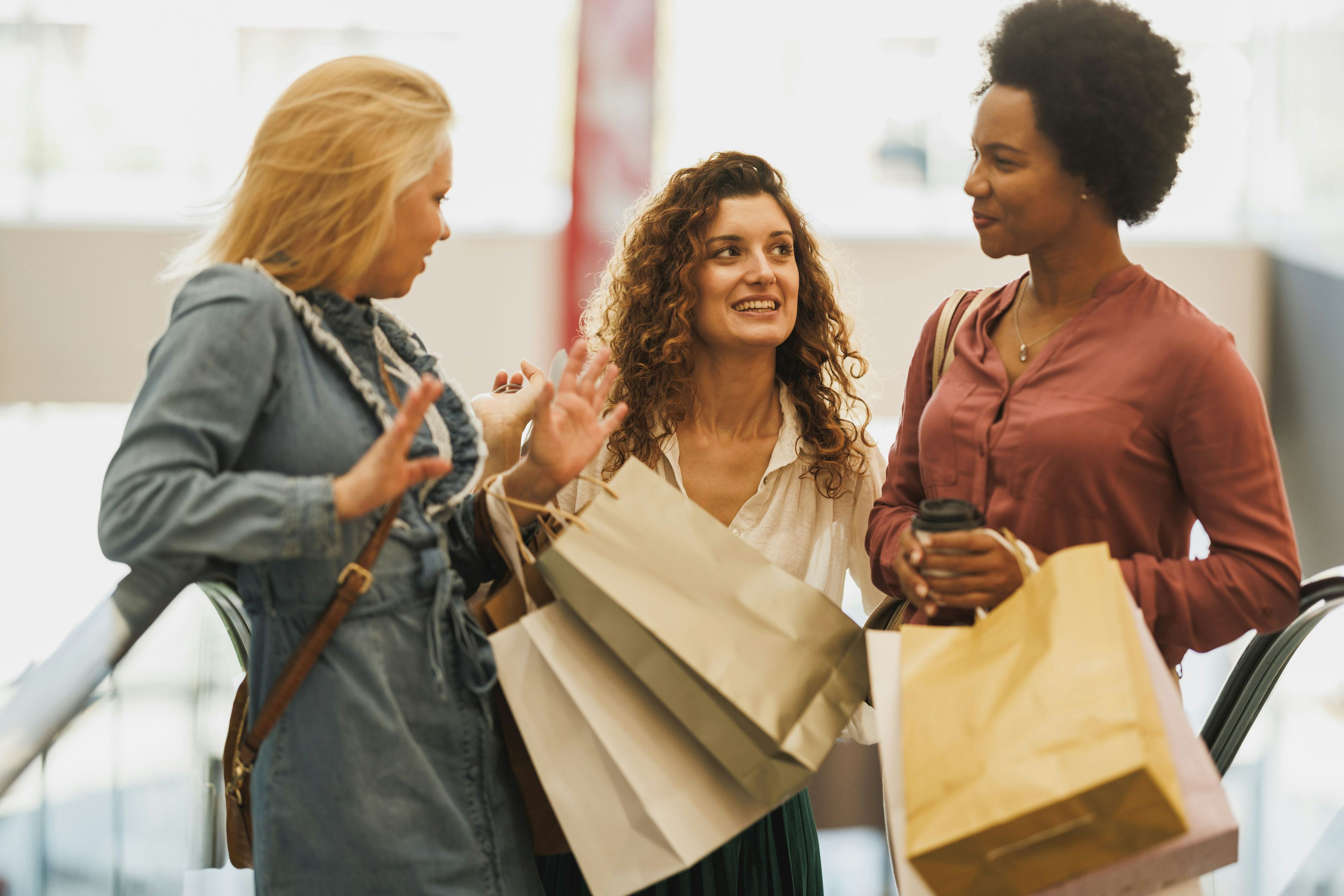 three women shopping at brightly lit mall together