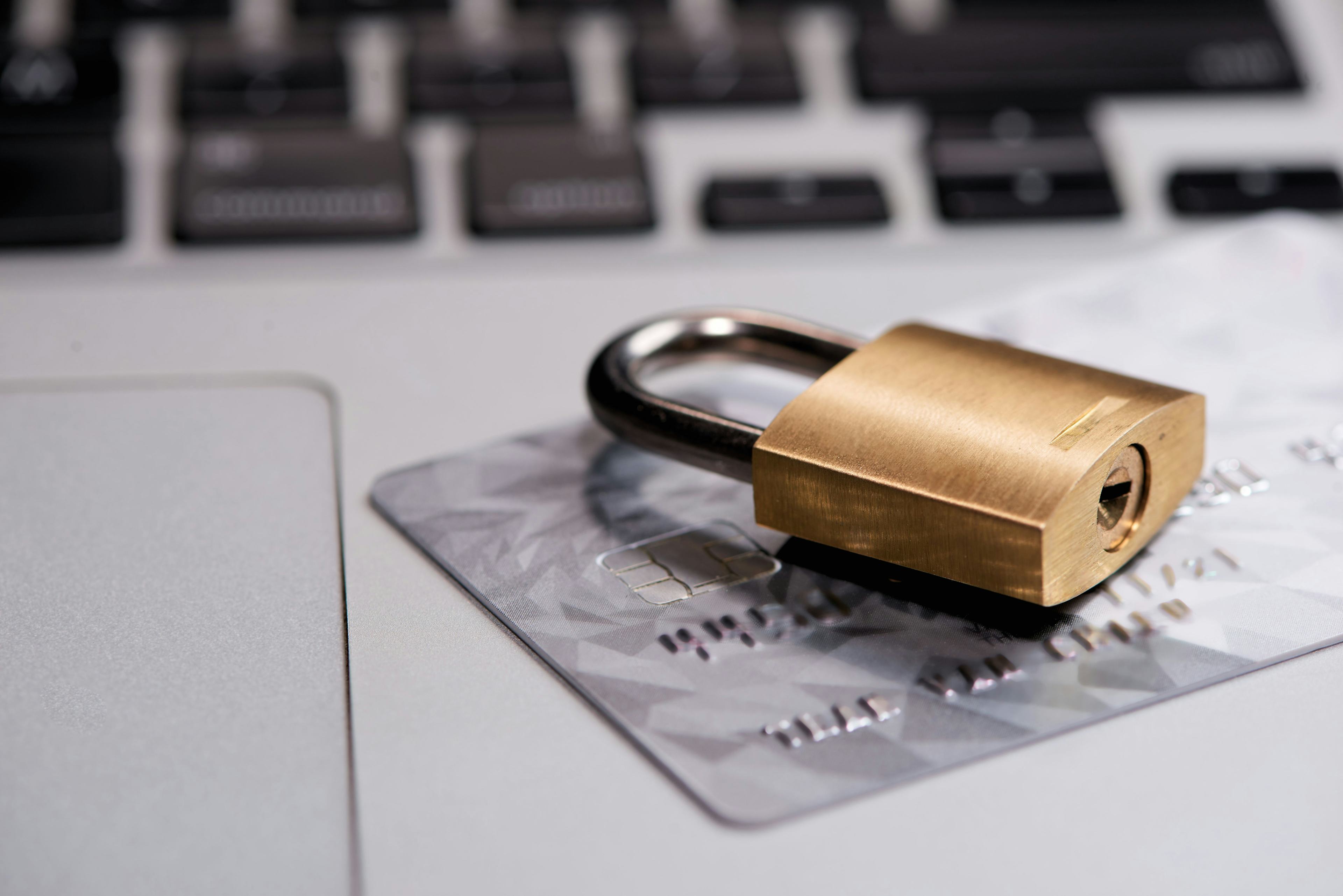 A lock and a credit card on top of an open computer.