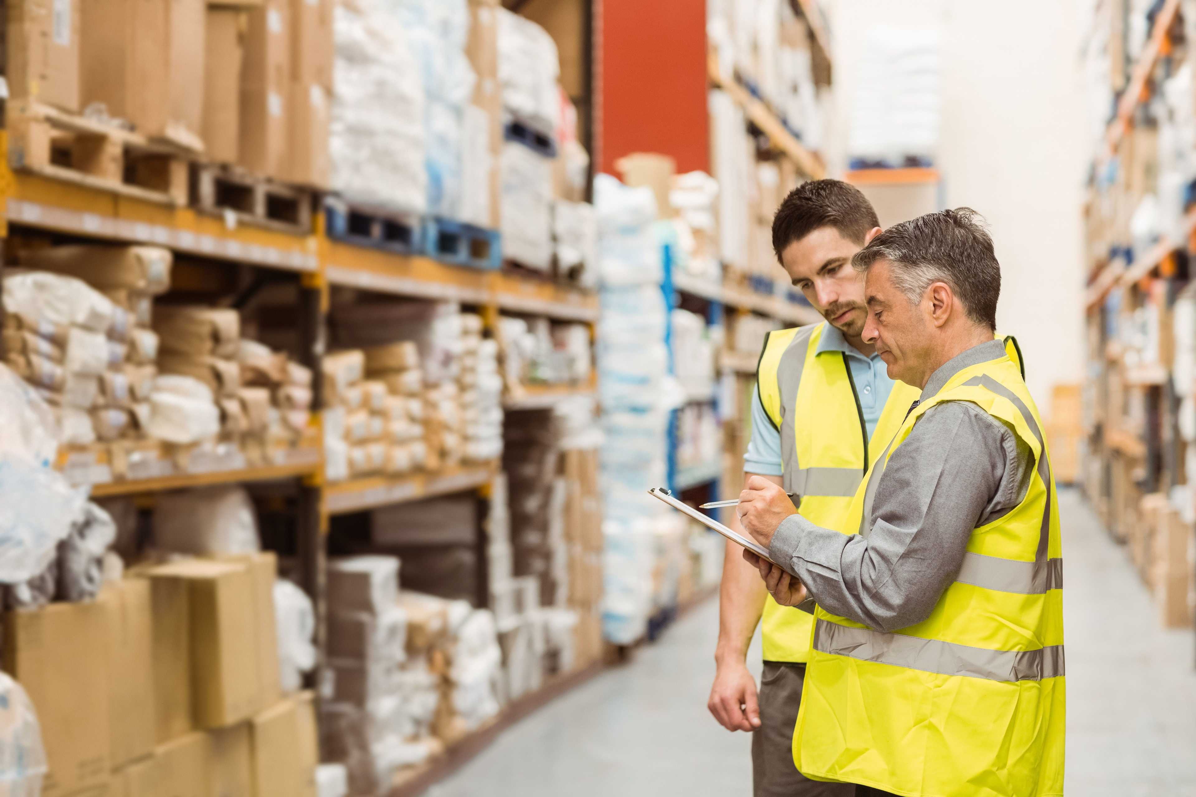 Warehouse workers talking together at work